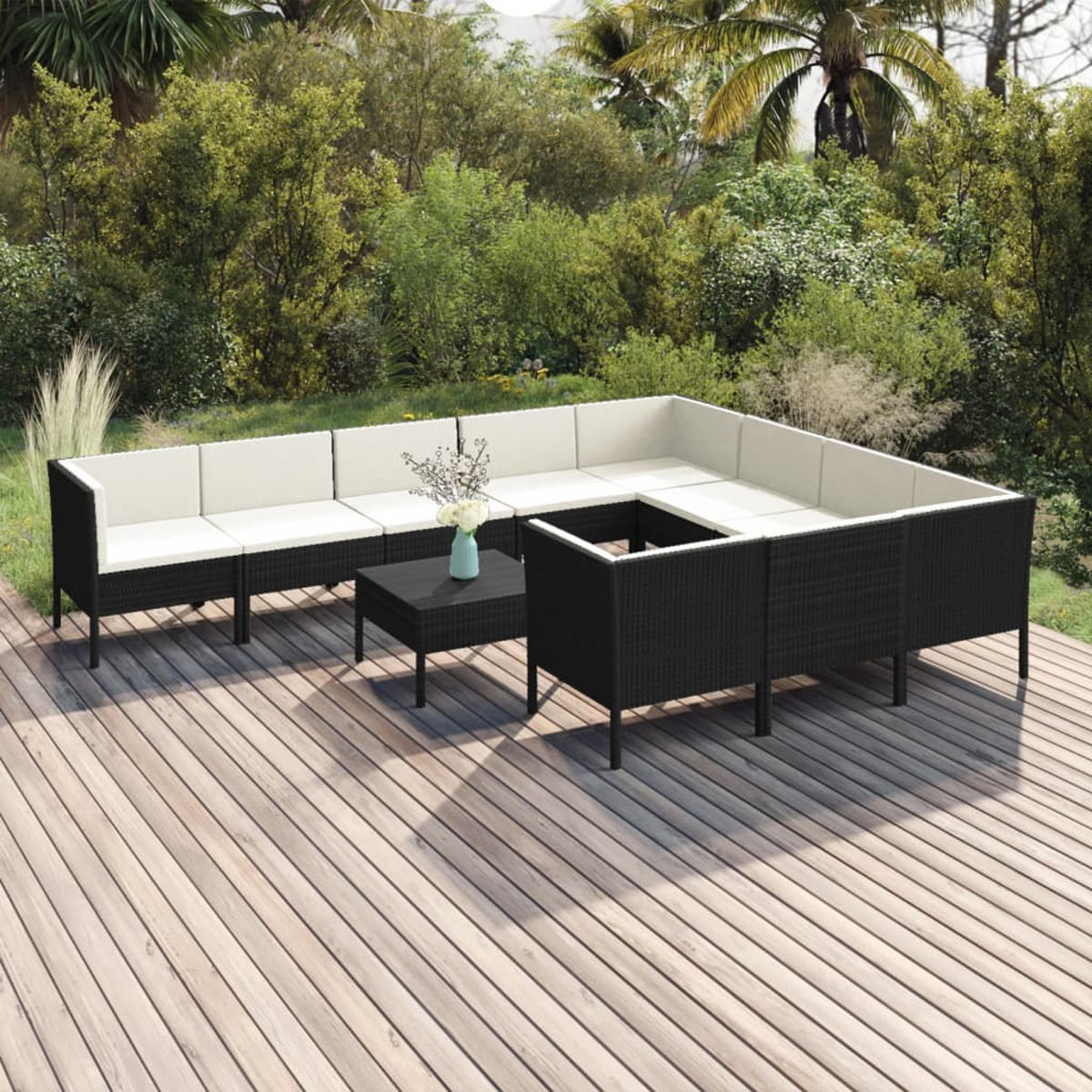 Ein schwarzes Rattan-Outdoor-Sofa-Set mit weißen Kissen und einem schwarzen Couchtisch auf einem Deck.