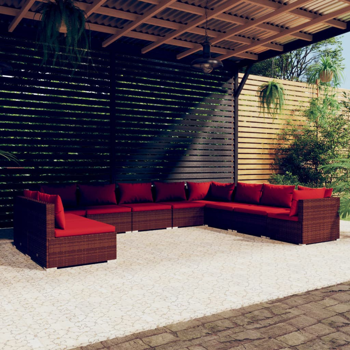 Outdoor-Ecksofa mit roten Kissen unter einer Holzpergola. Der Hintergrund hat grüne Pflanzen.
