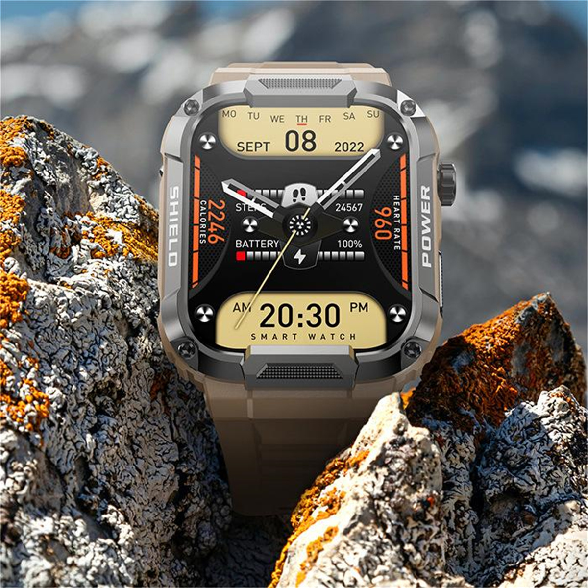 Smartwatch auf felsiger Oberfläche, zeigt Zeit, Akku und Kalorien. Der Hintergrund ist ein Berg.