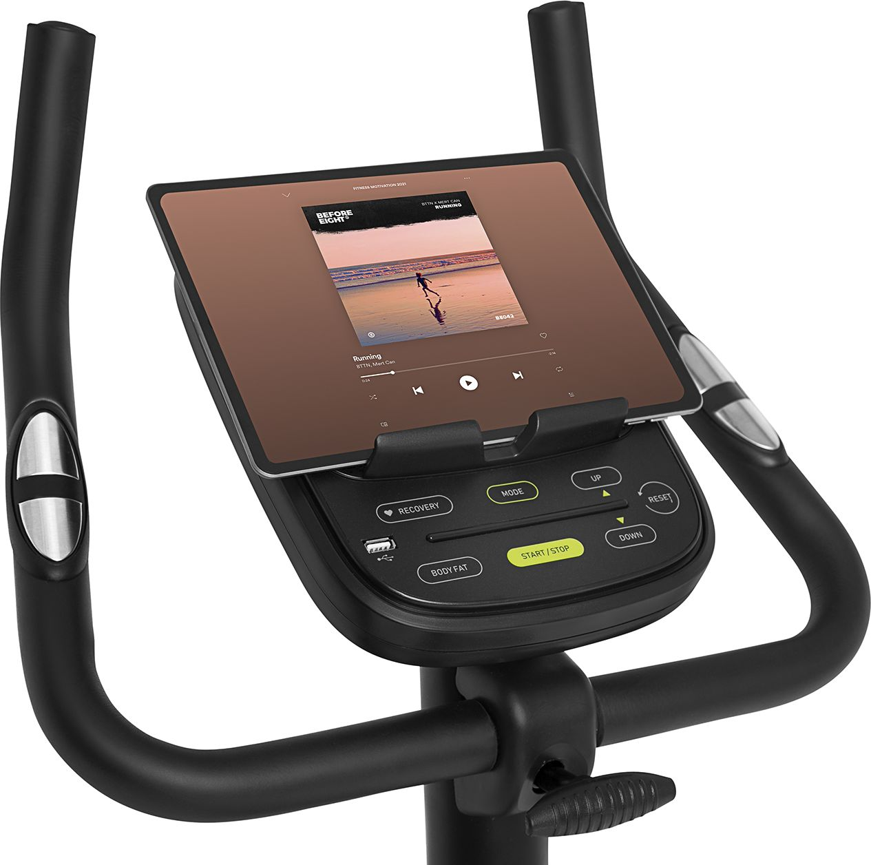 Stationäres Trainingsrad mit einem Tablet, das eine Musik-Player-Oberfläche anzeigt. Schwarze Griffe und Basis.
