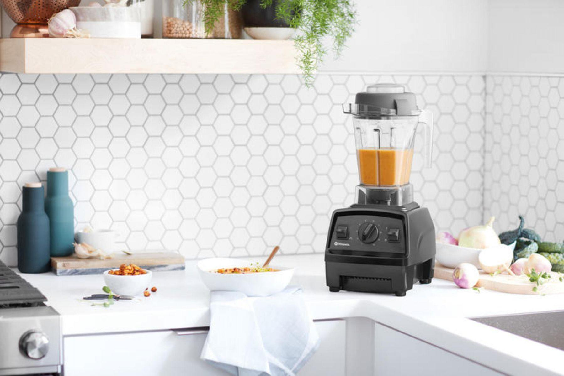 Küchenszene mit Mixer auf der Theke. Schüssel mit Essen, Gemüse und Regal.