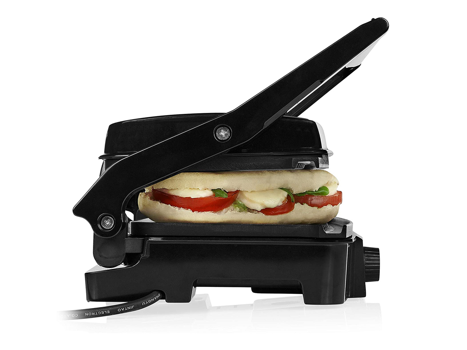 Schwarze Sandwichpresse mit einem Sandwich aus Tomaten, Mozzarella und Basilikum darin.