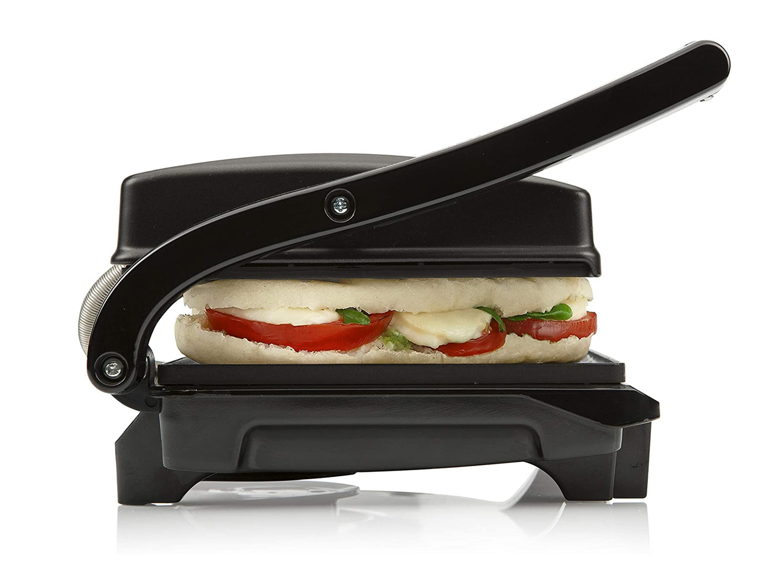 Una pressa per panini nera con un panino all'interno. Il panino ha pomodori e mozzarella.