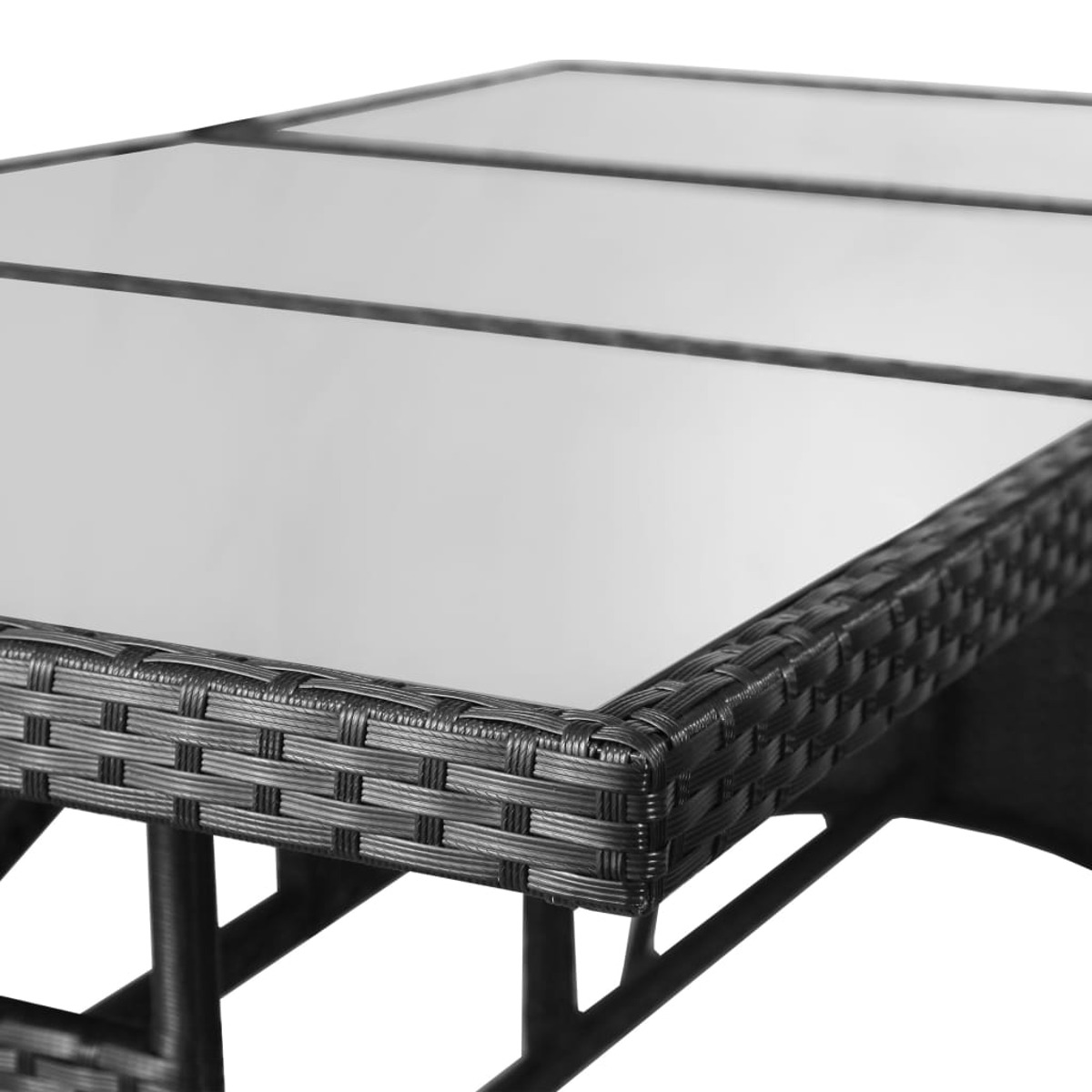 Primo piano di un tavolo con piano in vetro e cornice intrecciata scura.