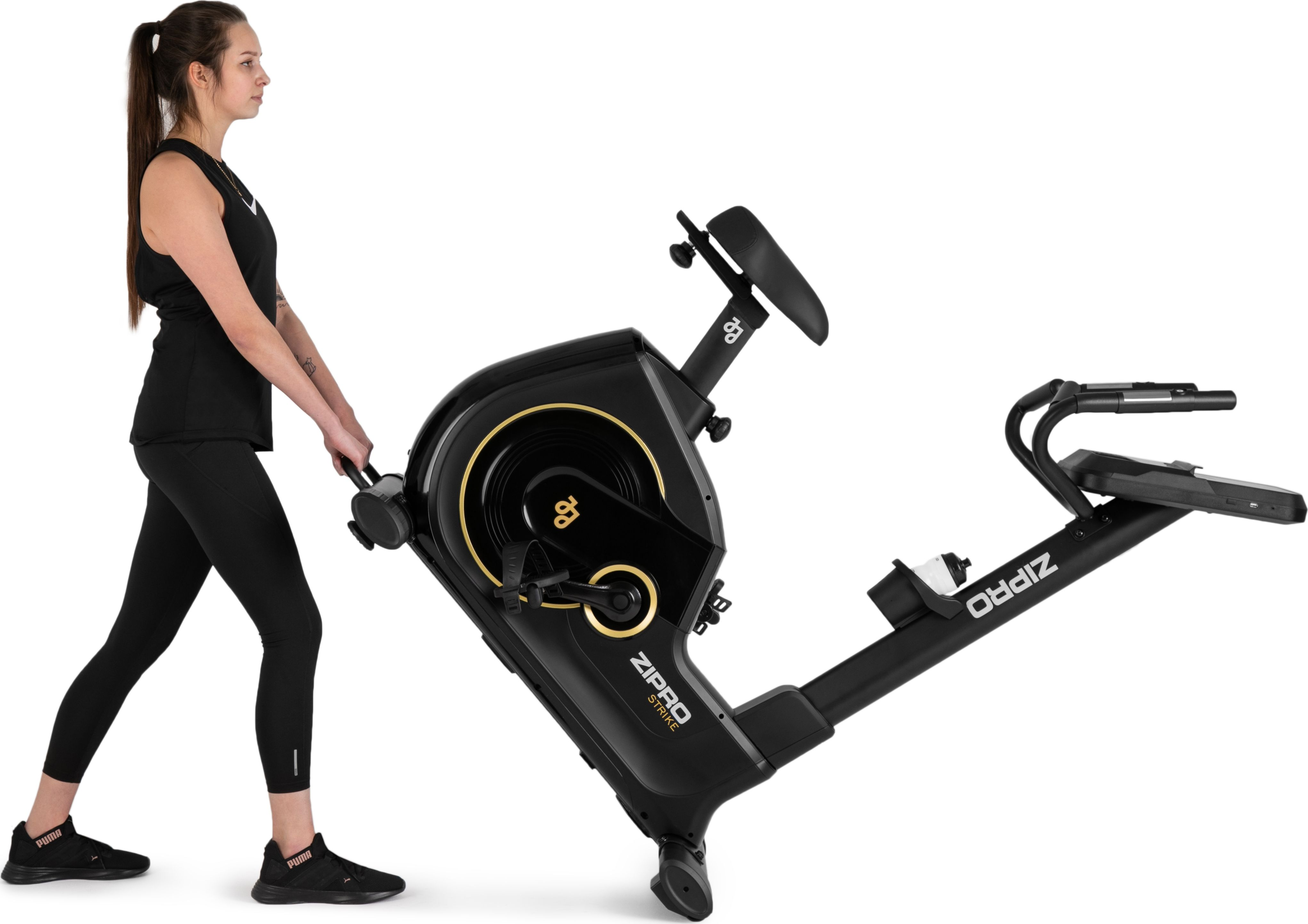 Frau in schwarzer Activewear schiebt ein stationäres Fahrrad, weißer Hintergrund.