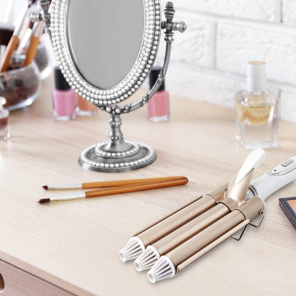 Schminktisch mit Spiegel, Pinseln, Nagellack und einem Lockenstab.