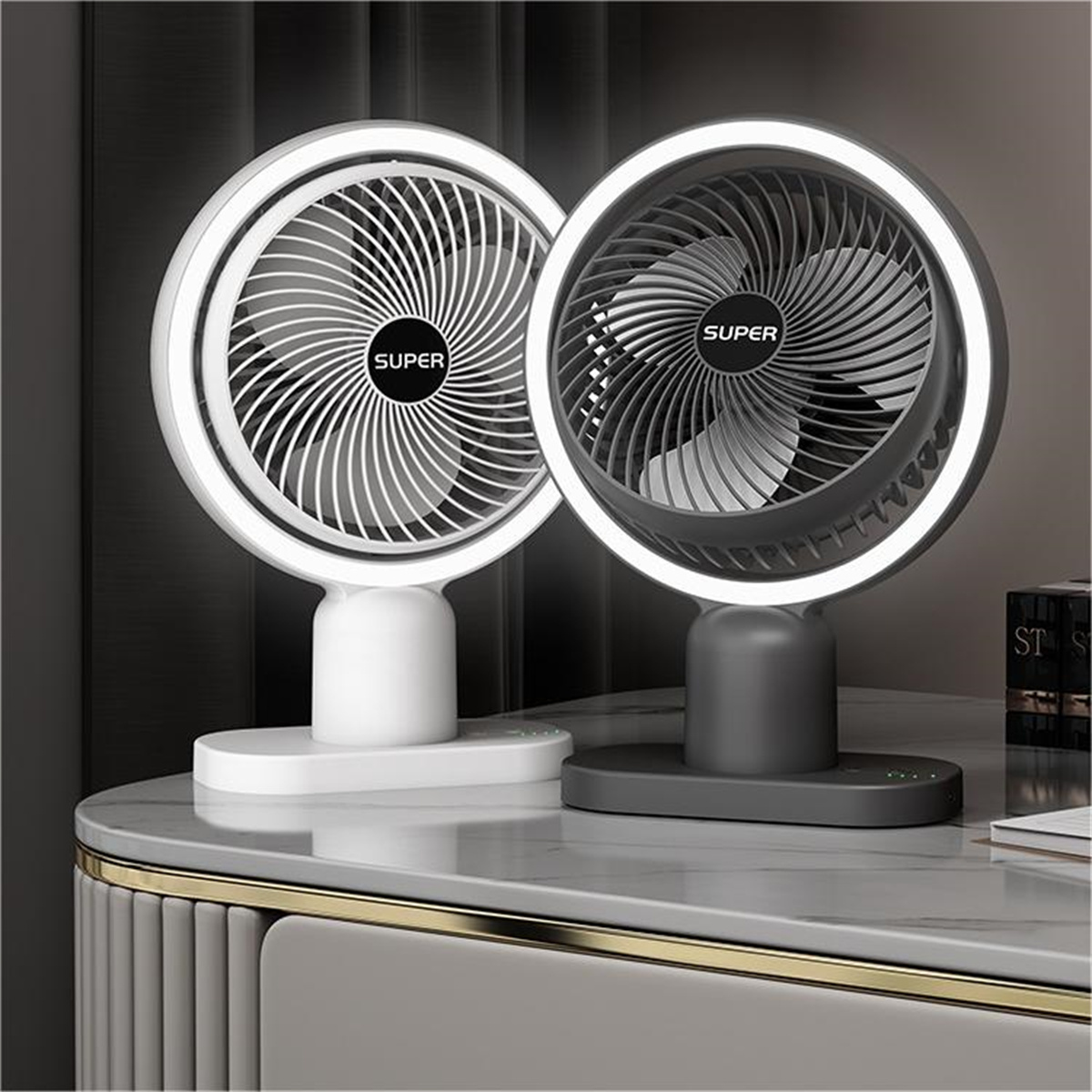 Dos ventiladores blancos y gris oscuro con anillo de luz blanco. Están sobre una superficie de mármol.