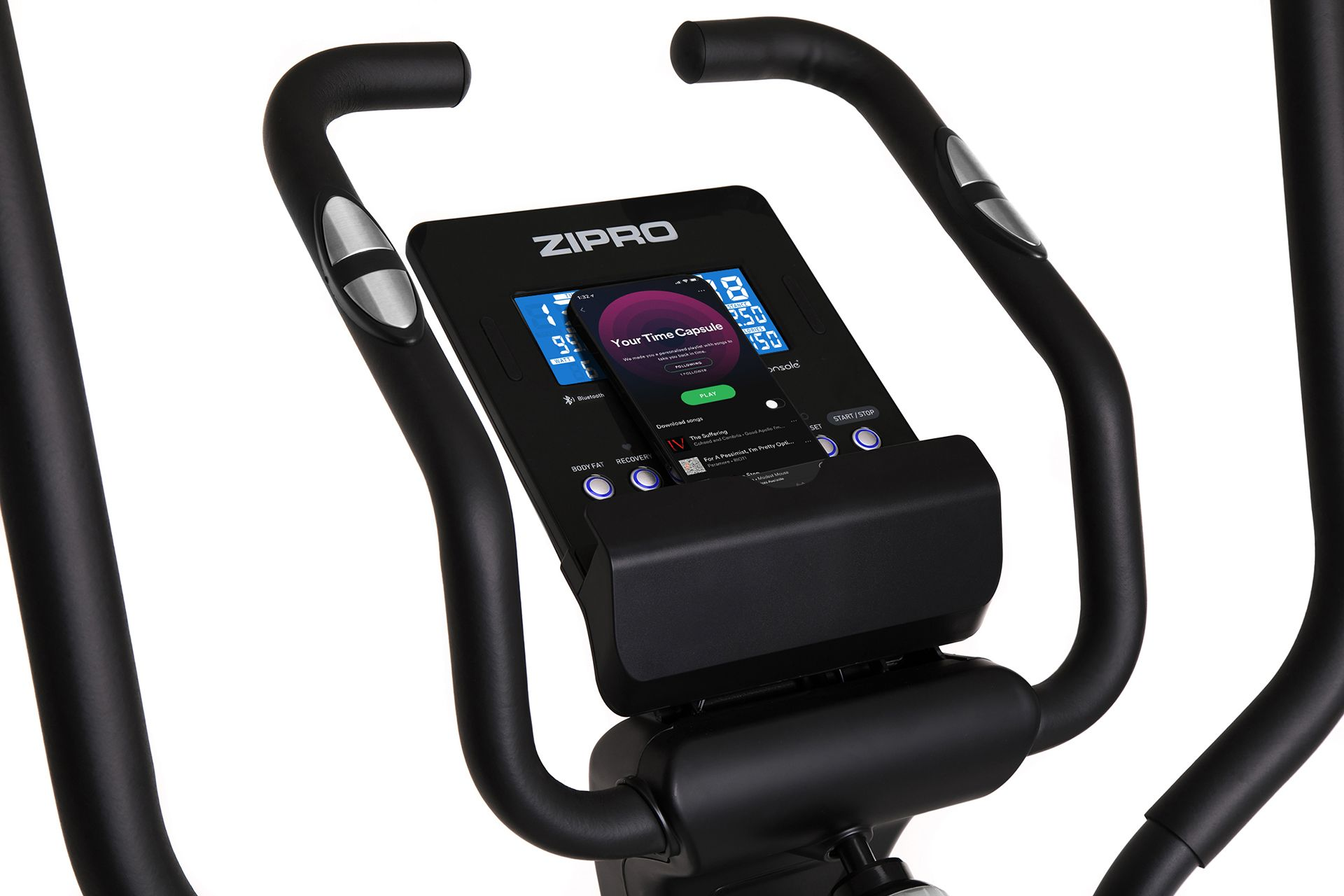 Czarna konsola urządzenia do ćwiczeń. Wyświetlacz pokazuje aplikację muzyczną, uchwyty i szyny boczne.