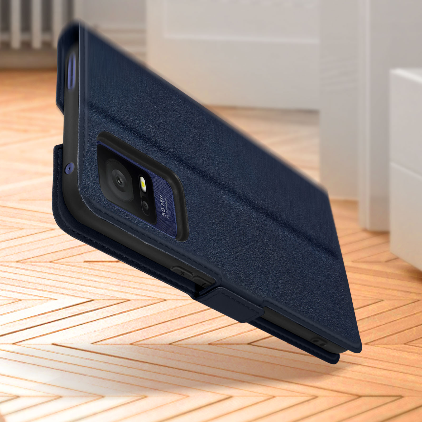 Una custodia per telefono blu scuro con un telefono dentro, appoggiata su una superficie di legno vicino a una porta bianca.