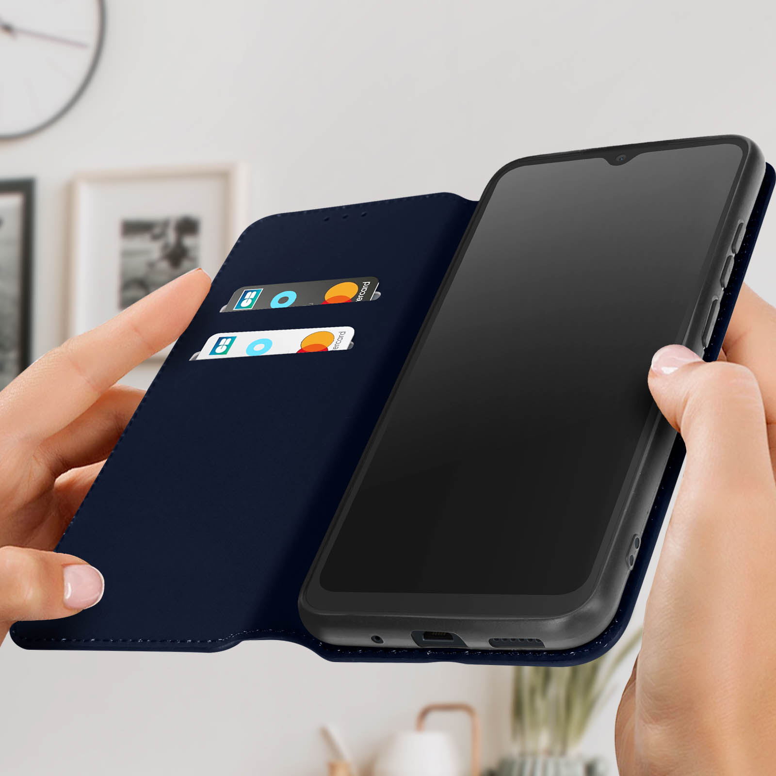 Mani che tengono una custodia per telefono blu scuro aperta, mostrando carte e un telefono.