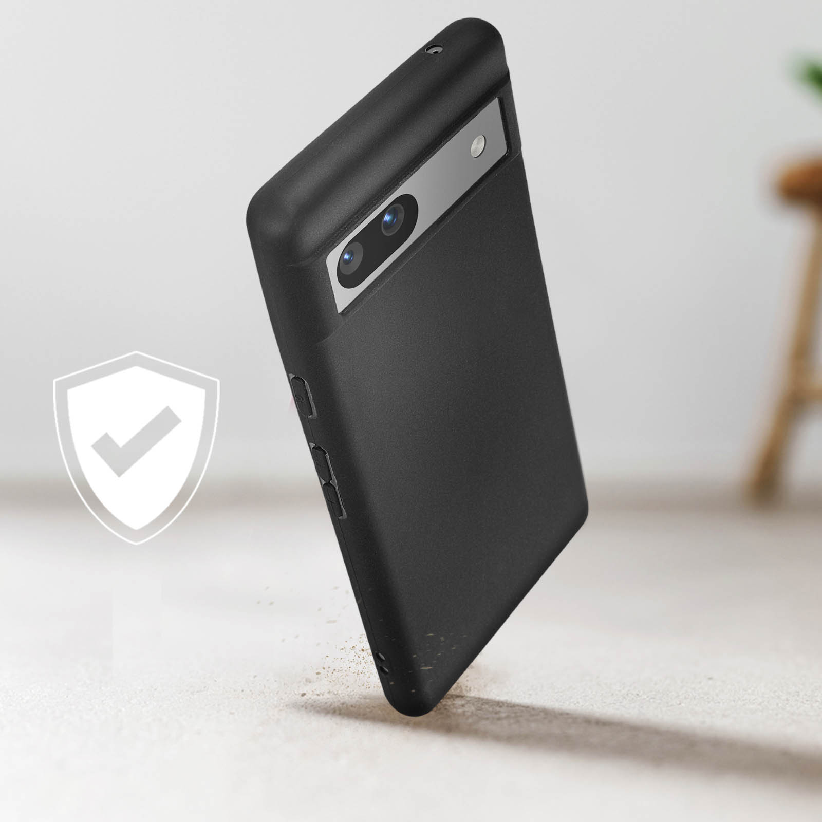 Een zwarte telefoonhoes met een zilveren camerabalk en de telefoon ligt op de grond.
