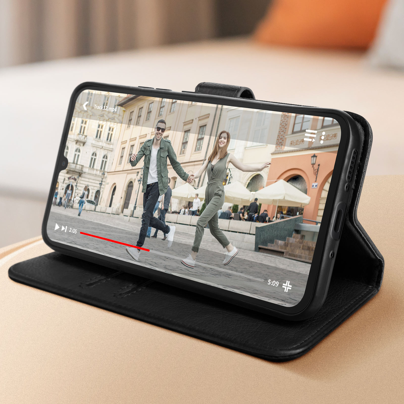 Smartphone in custodia nera che riproduce un video di una coppia che corre in una città.