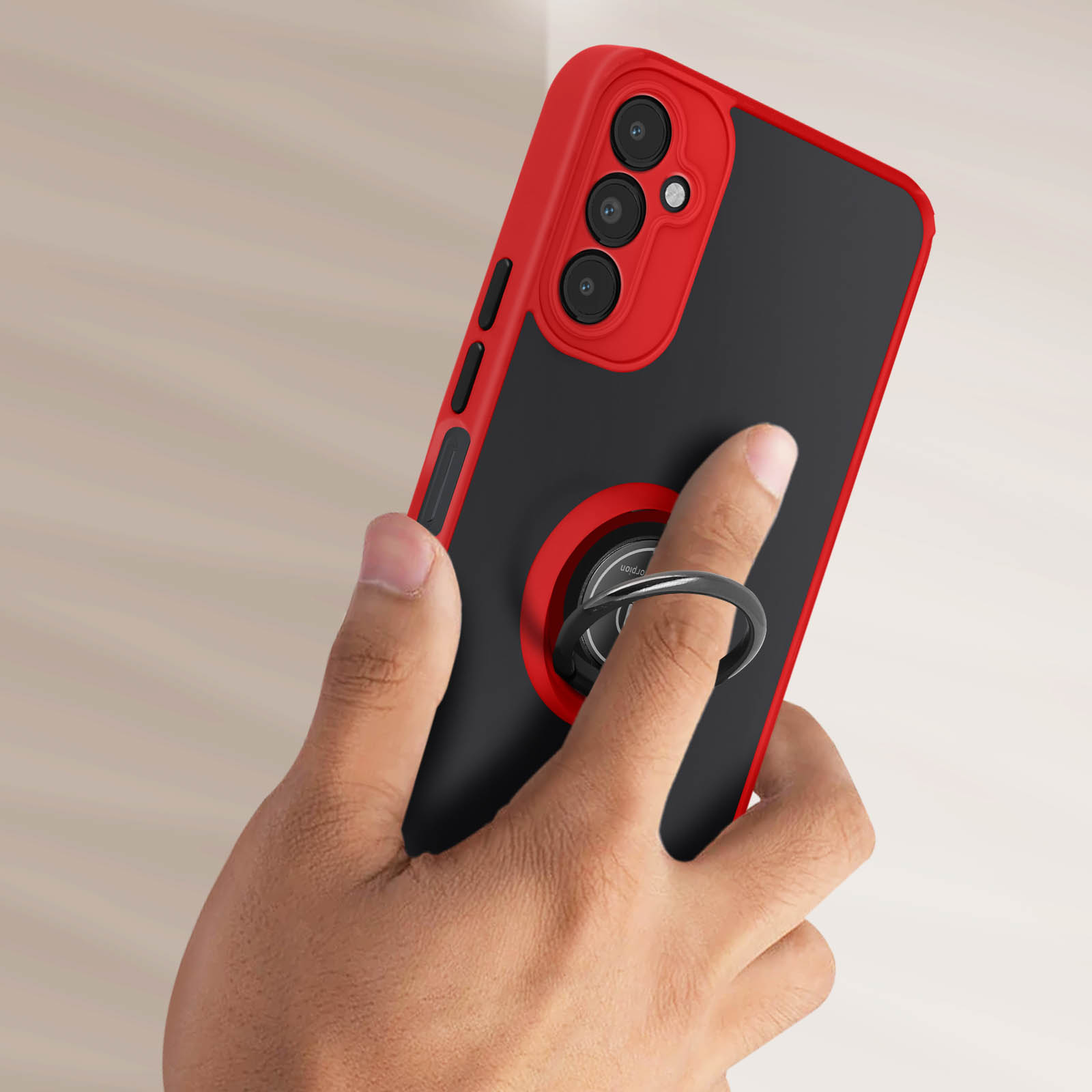 Mano che tiene un telefono in una custodia rossa e nera, con un supporto ad anello.