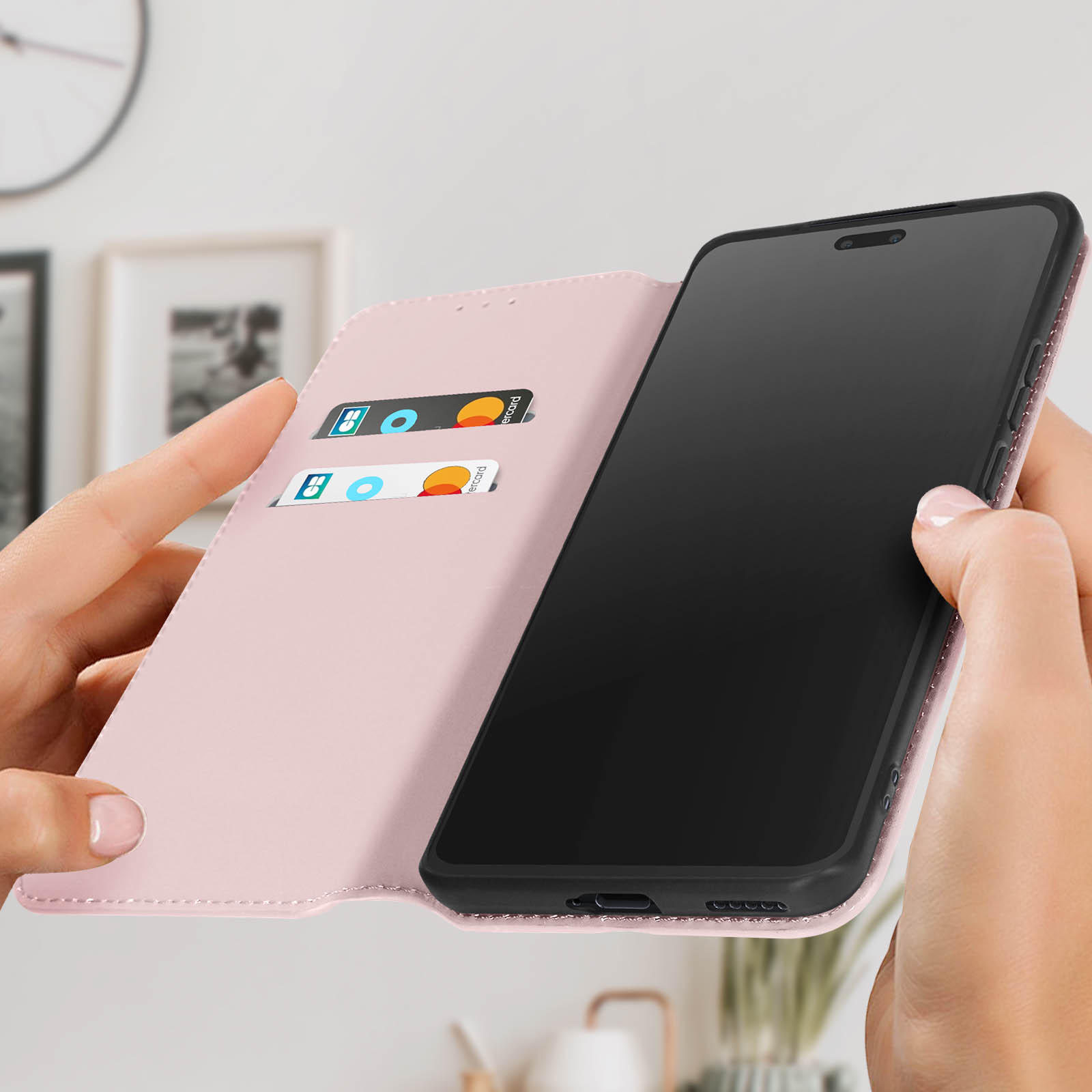 Una custodia rosa per telefono con un telefono all'interno, tenuta in mano. Fessure per carte di credito visibili. Sfondo bianco.
