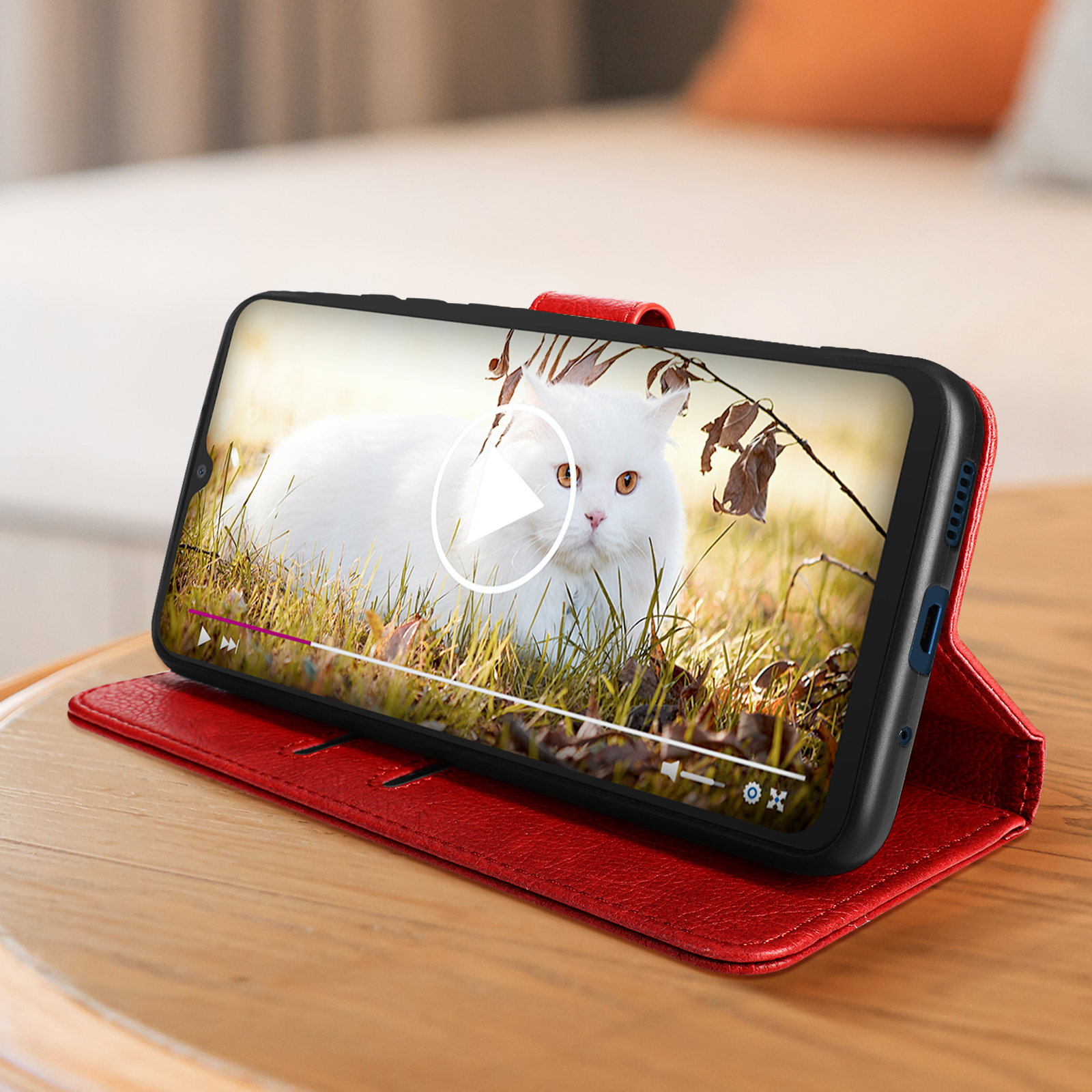 Smartphone in custodia di pelle rossa che mostra un video di un gatto bianco.
