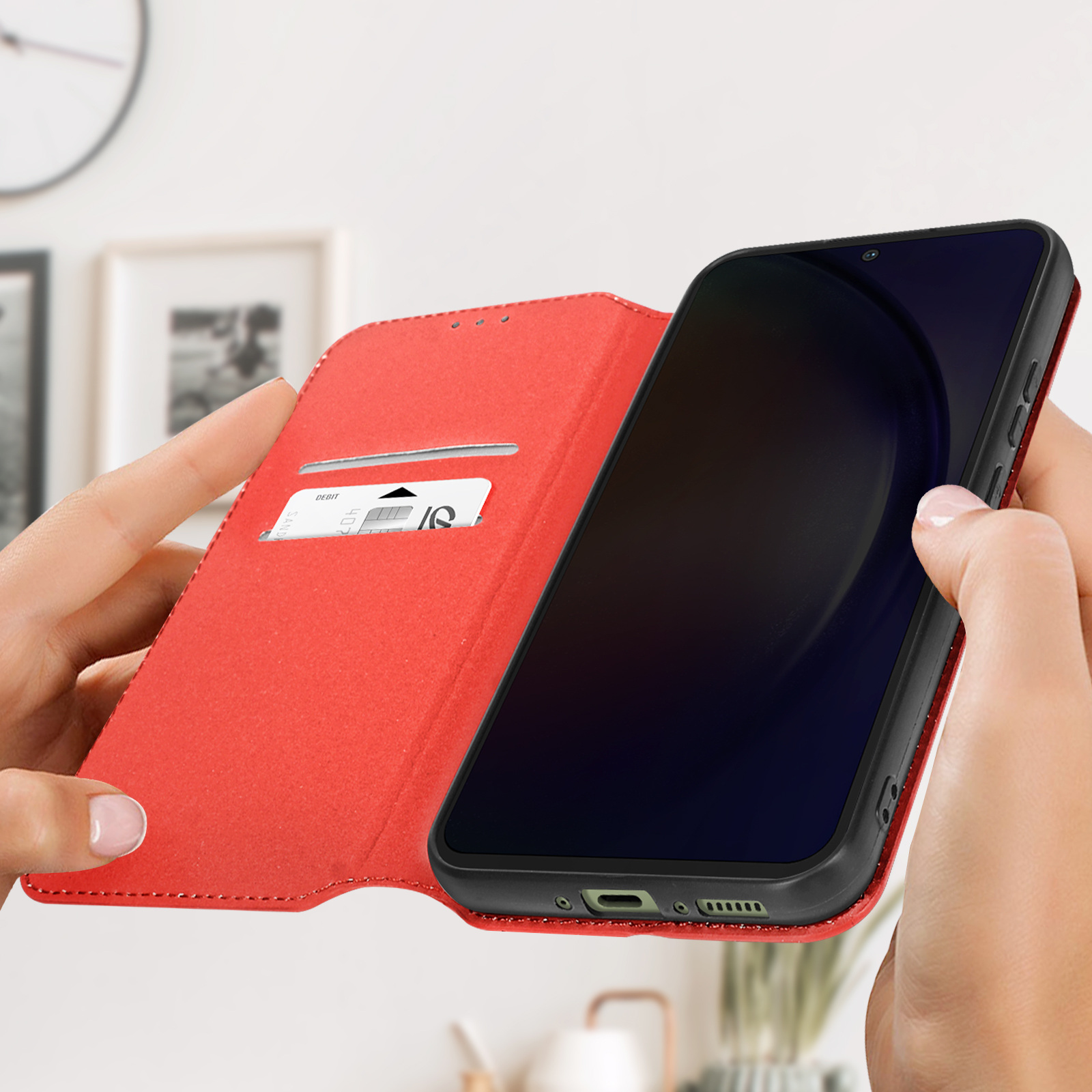 Una custodia rossa per telefono, aperta, che tiene in mano uno smartphone nero con schermo scuro.
