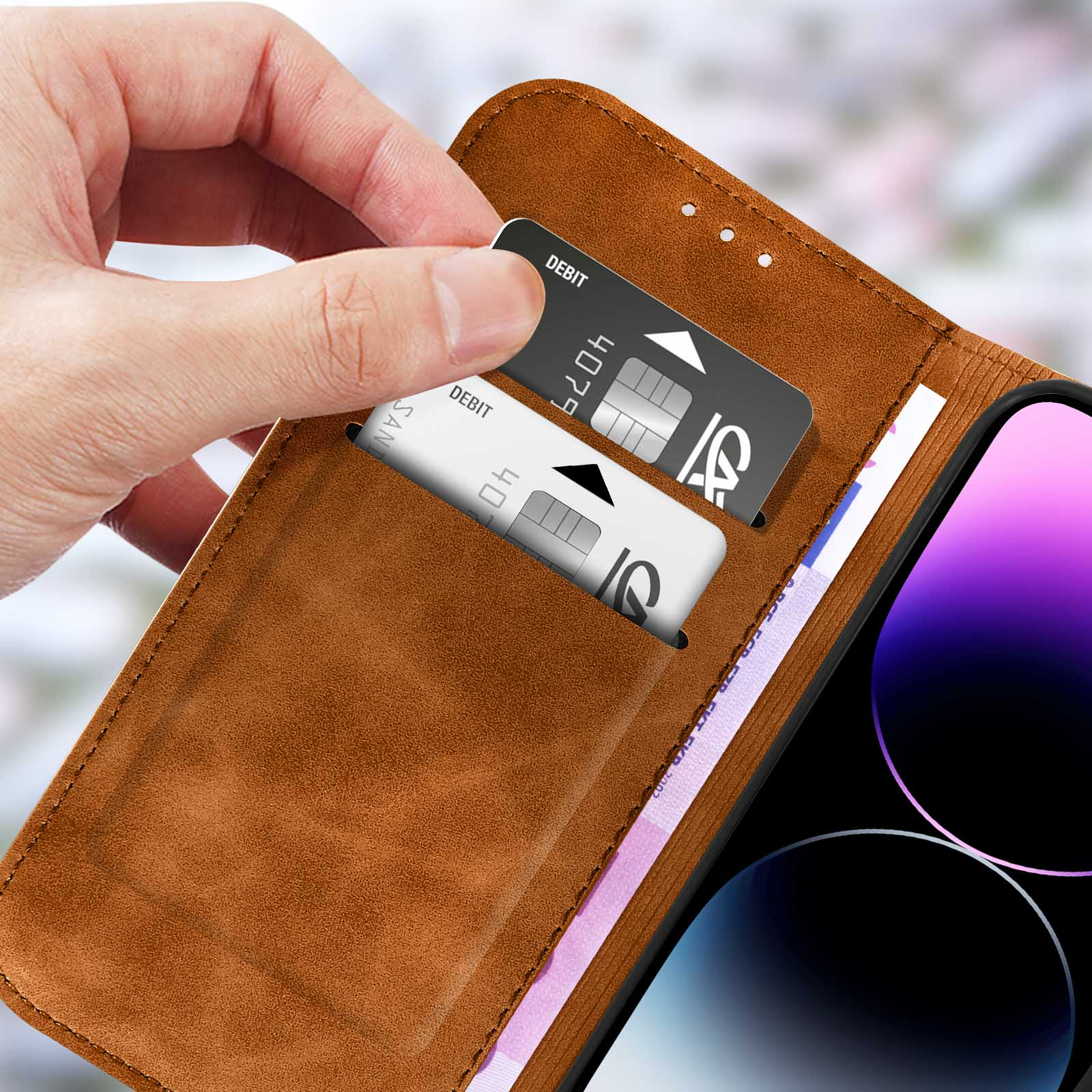 Hand öffnet eine Handyhülle, zeigt Kreditkarten in einer Tasche, Lederstruktur.