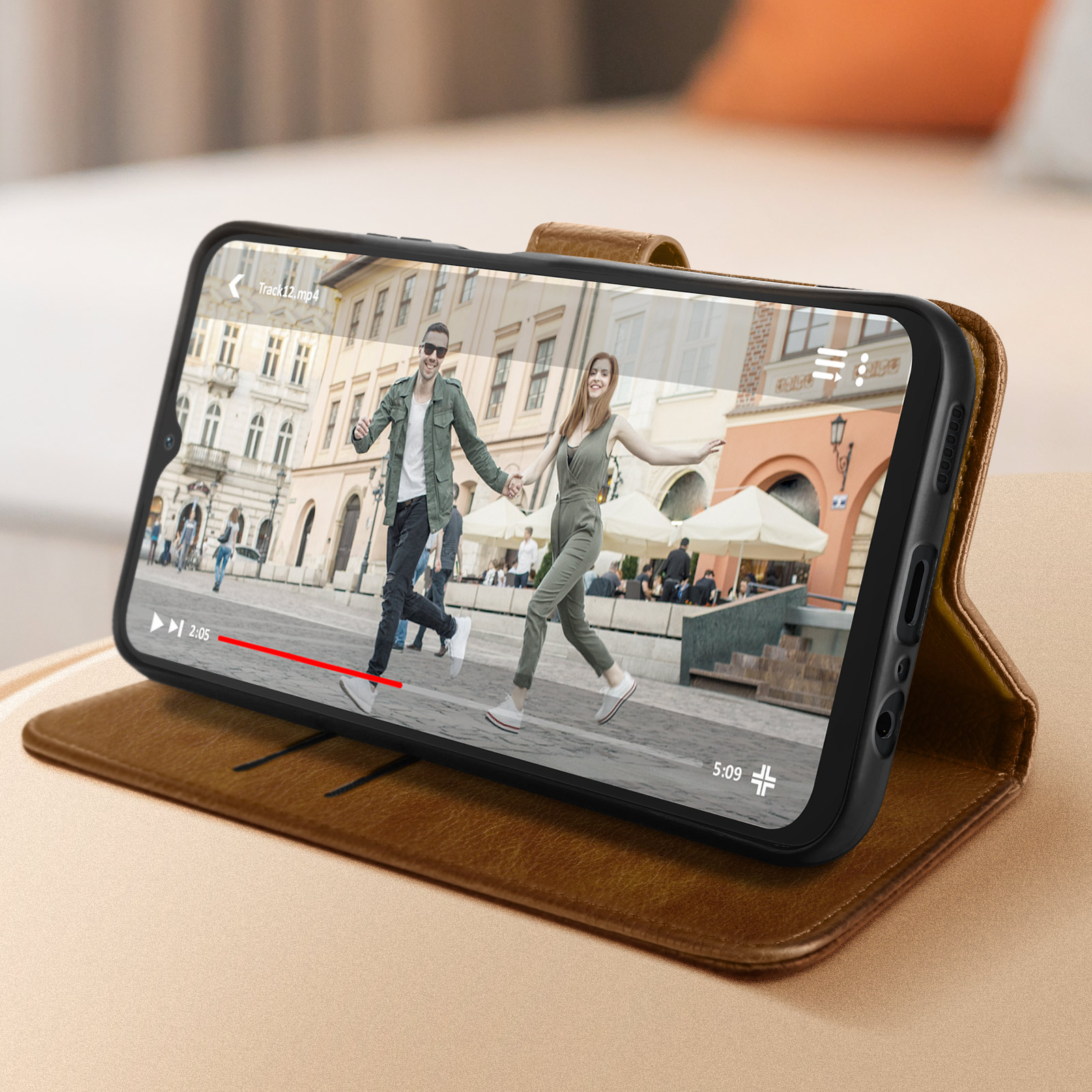 Smartphone mit Video von rennenden Leuten, in brauner Hülle.