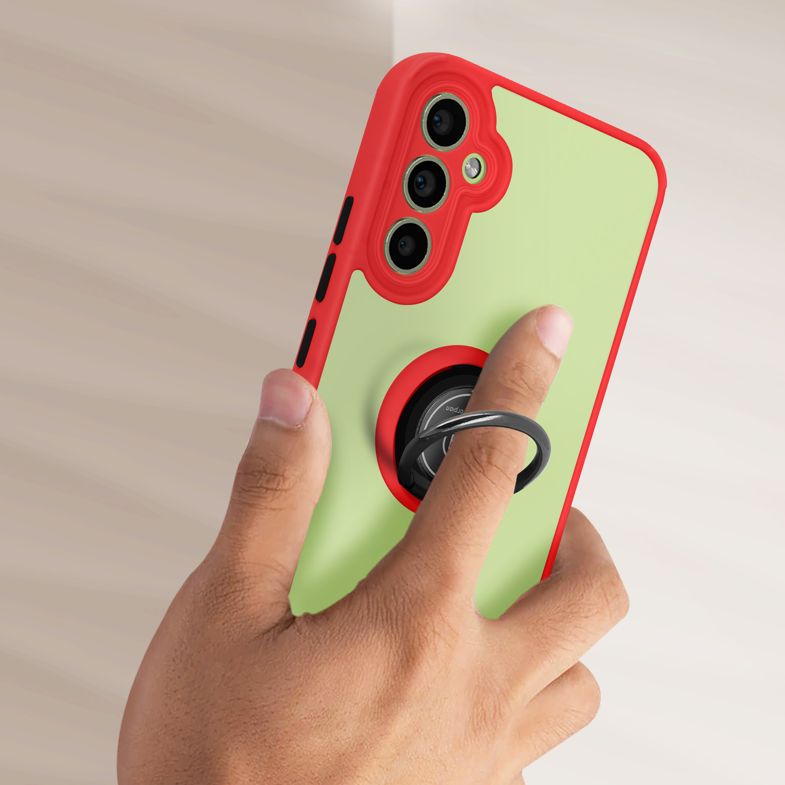 Una mano che tiene un telefono con una custodia rossa e verde con un supporto ad anello. La custodia ha un anello nero.