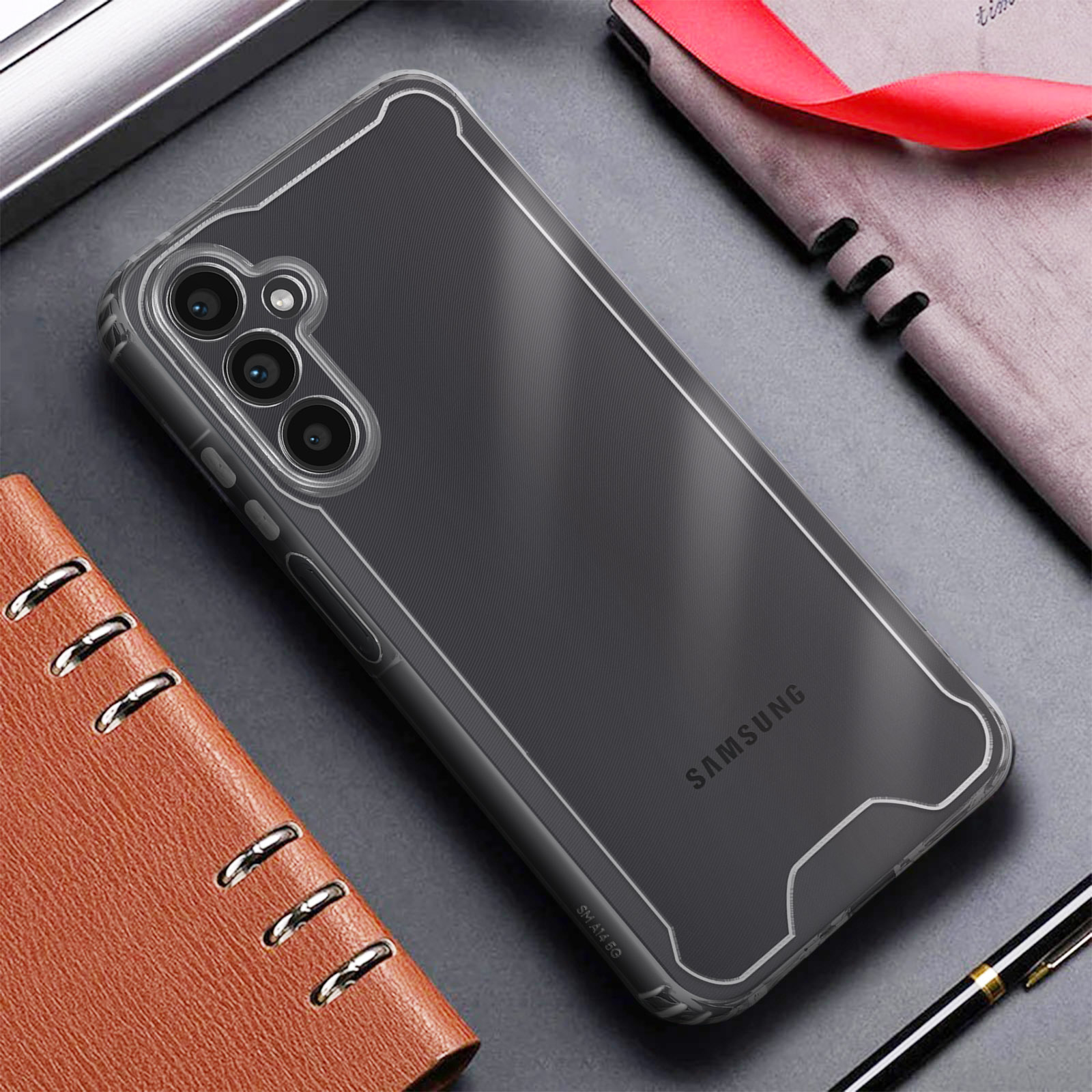 Coque transparente pour téléphone sur un bureau. Cahier marron et stylo à côté.