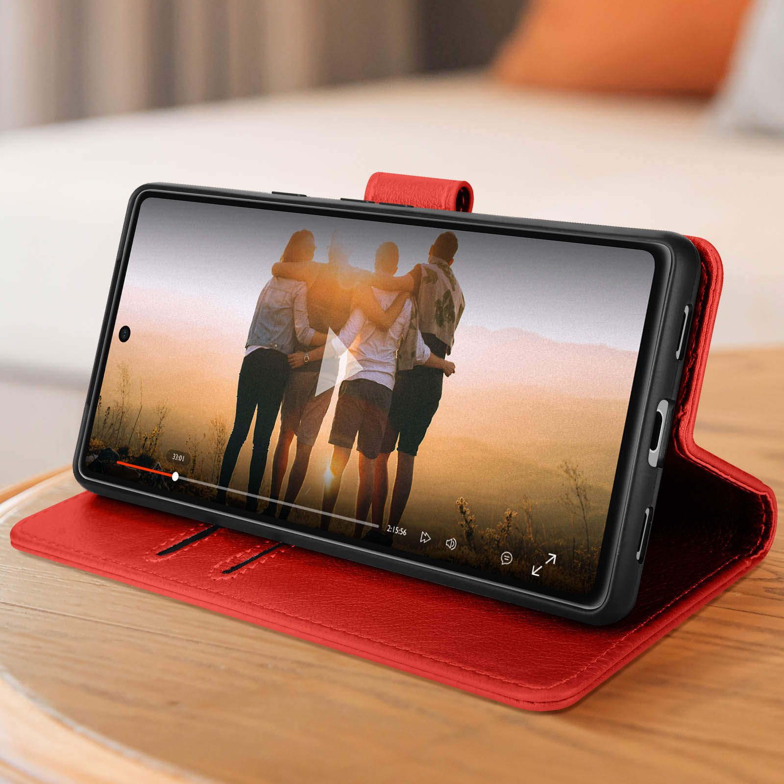 Ein Smartphone in einer roten Hülle spielt ein Video von Freunden ab.