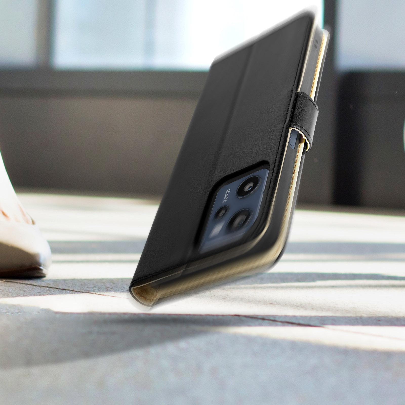 Una custodia per telefono nera aperta su una superficie. La custodia è nera, l'interno è dorato.