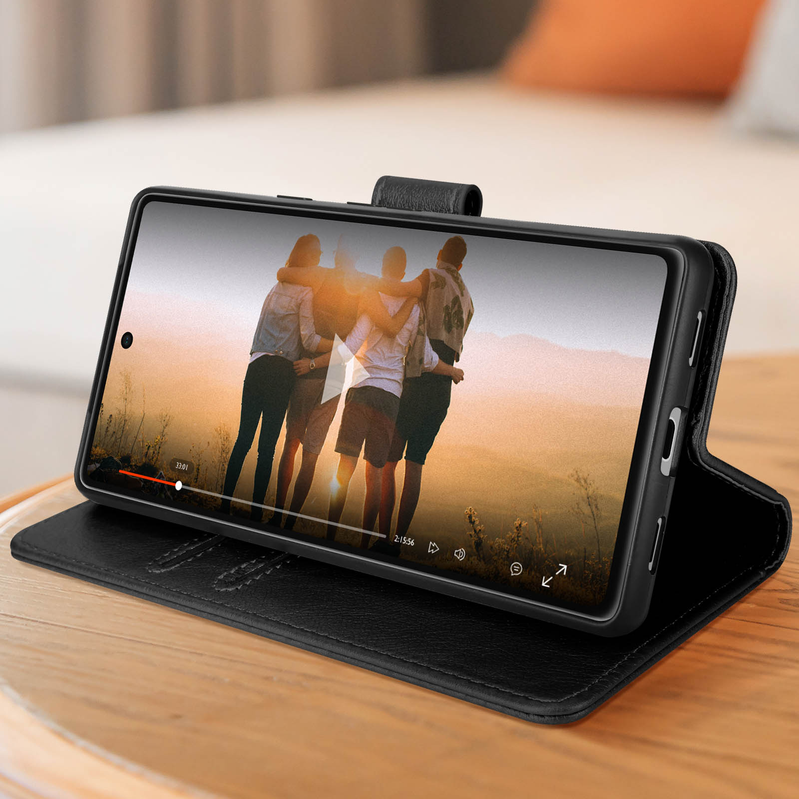 Uno smartphone in una custodia in pelle nera mostra un video di persone.