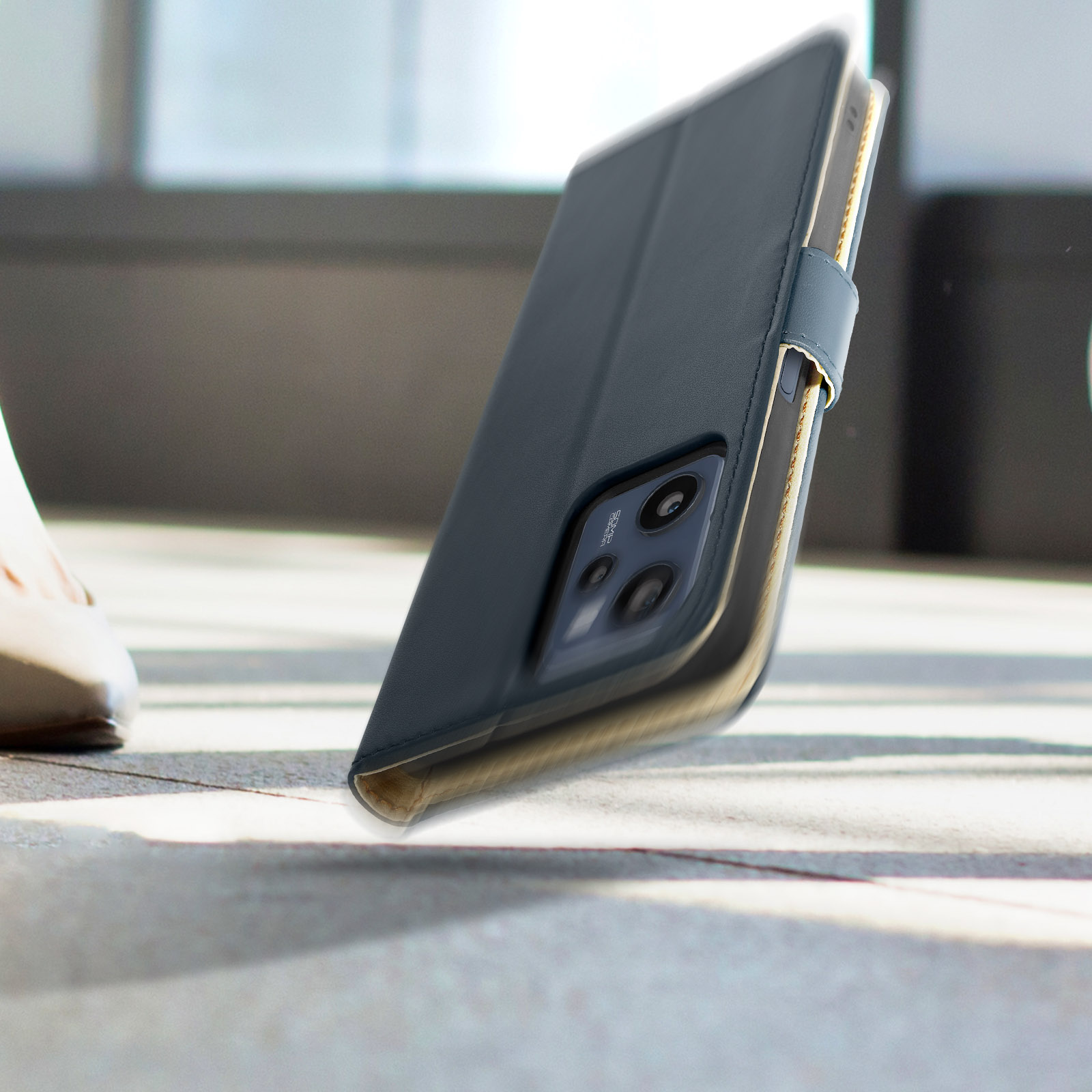 Custodia nera per telefono con cinturino grigio, aperta, su una superficie.