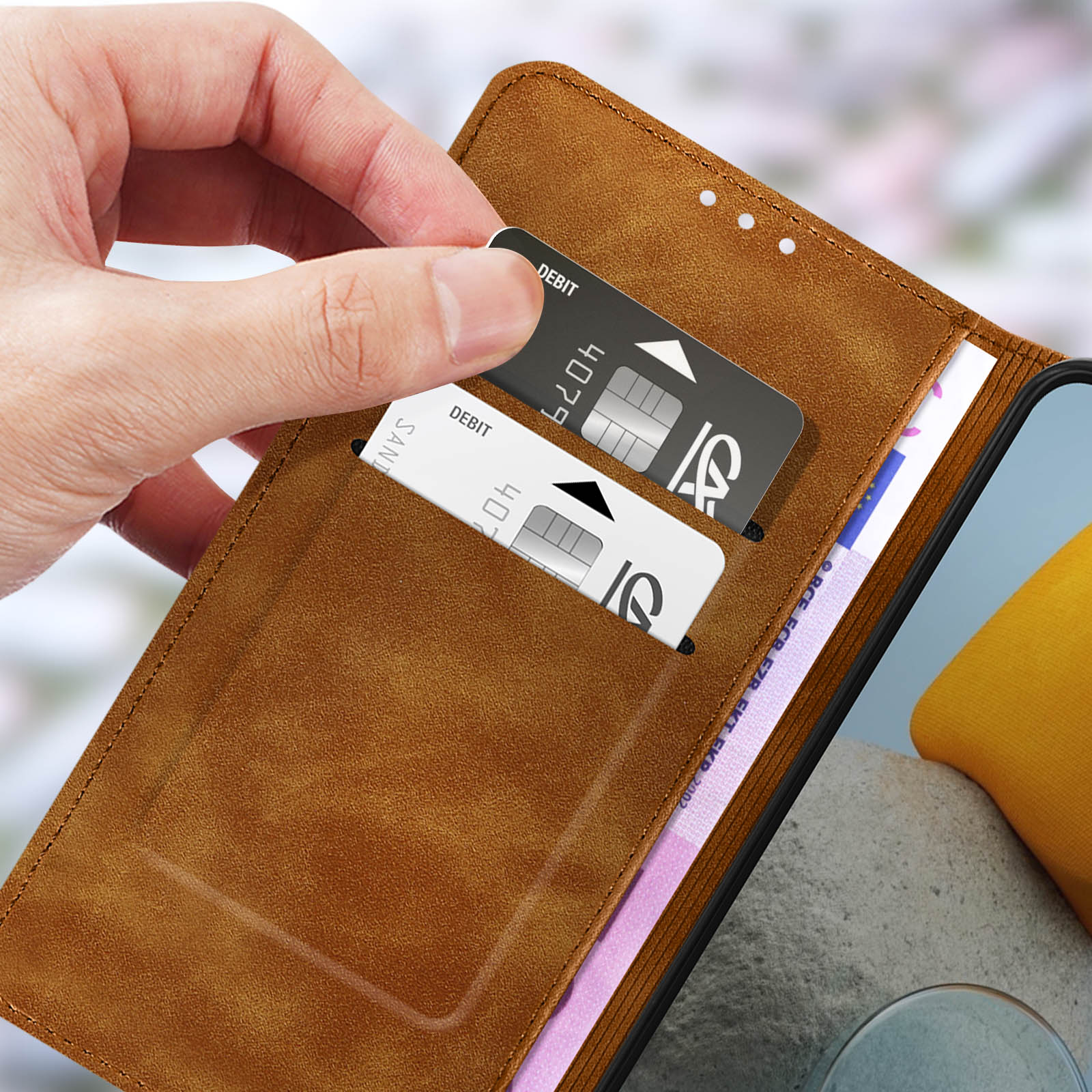 Mano che tiene carte di credito in una custodia per telefono dall'aspetto in pelle.