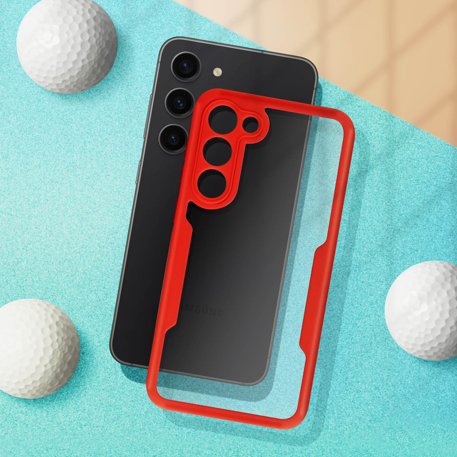 Telefono nero in custodia rossa, con palline da golf, su superficie blu.
