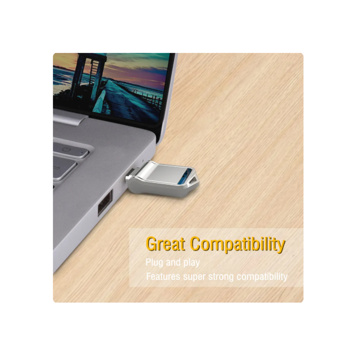 Una unidad flash USB plateada insertada en una laptop. El texto dice 'Great Compatibility'.