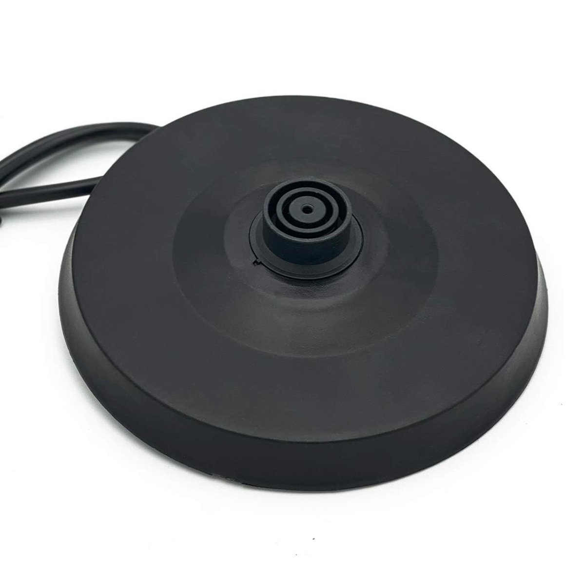 Base negra de hervidor eléctrico con conector central de plástico sobre superficie blanca.