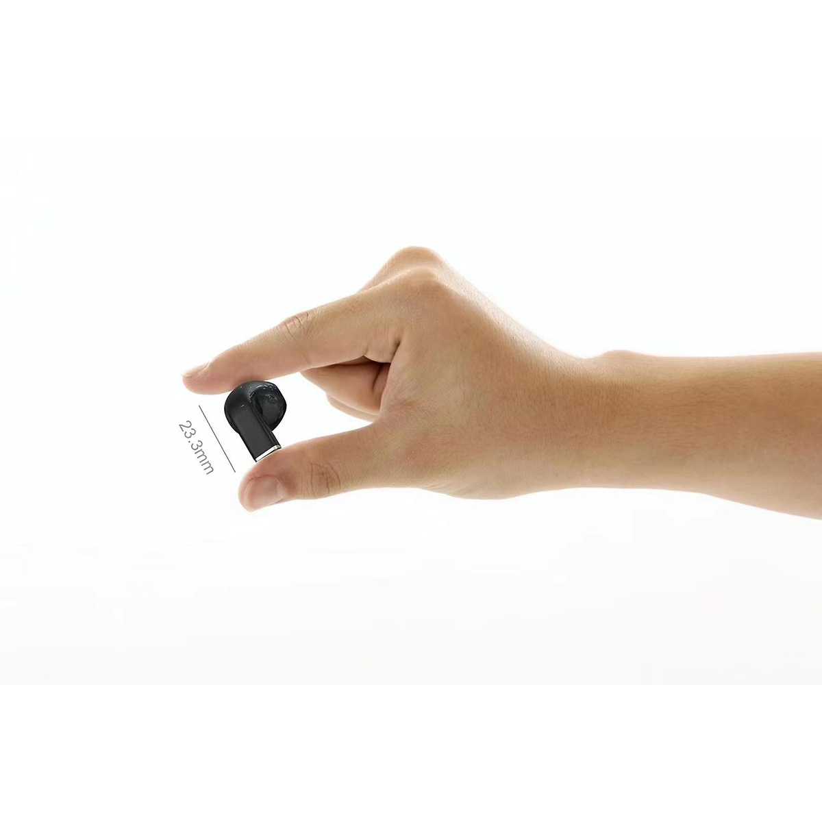 Una mano sostiene un pequeño auricular negro, 23,3 mm es el tamaño.