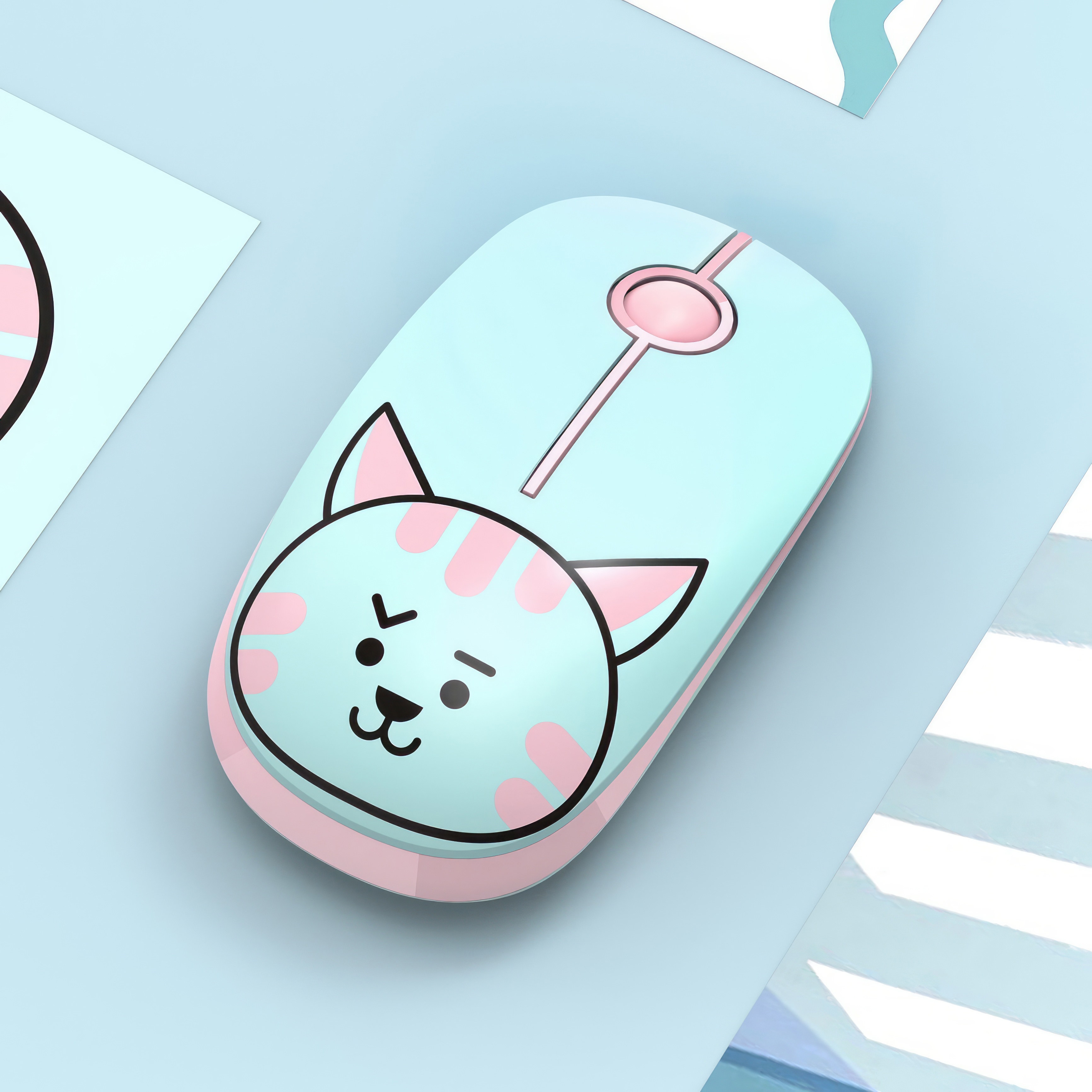 Niebiesko-różowa mysz komputerowa z motywem kota na jasnoniebieskiej powierzchni. Widoczny różowy przycisk.