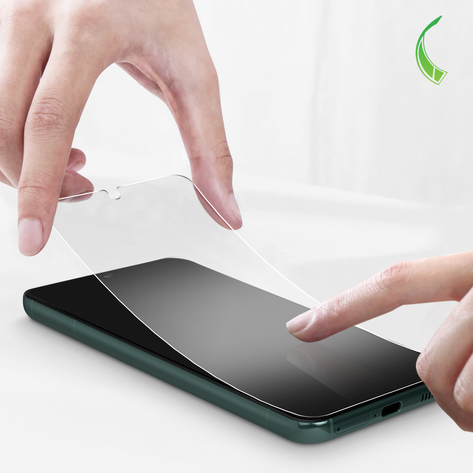 Mani che posizionano una protezione per lo schermo su un telefono verde scuro. Una protezione per lo schermo trasparente in aria.