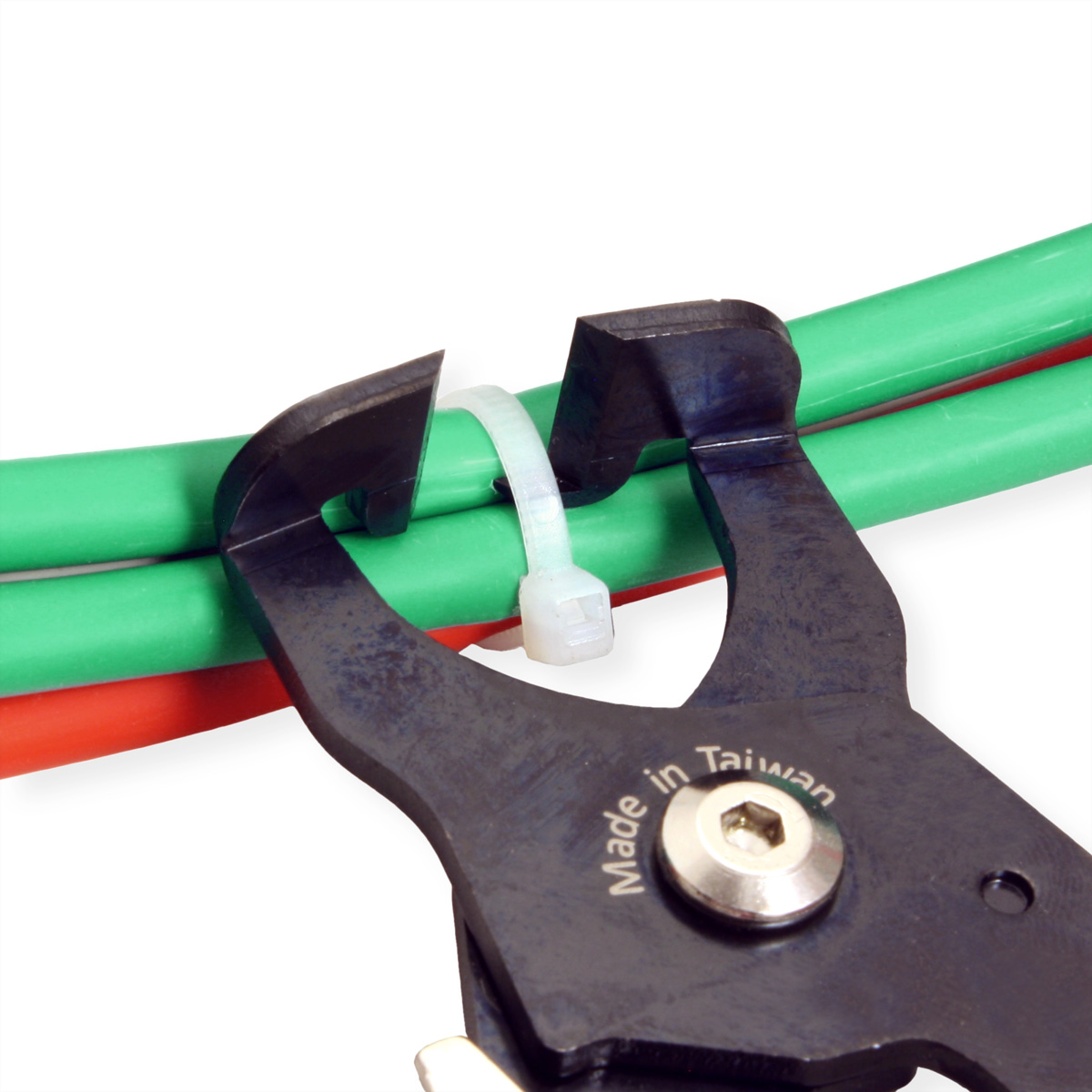 Pliers cutting a white cable tie. Two green and red wires in the background. White background.