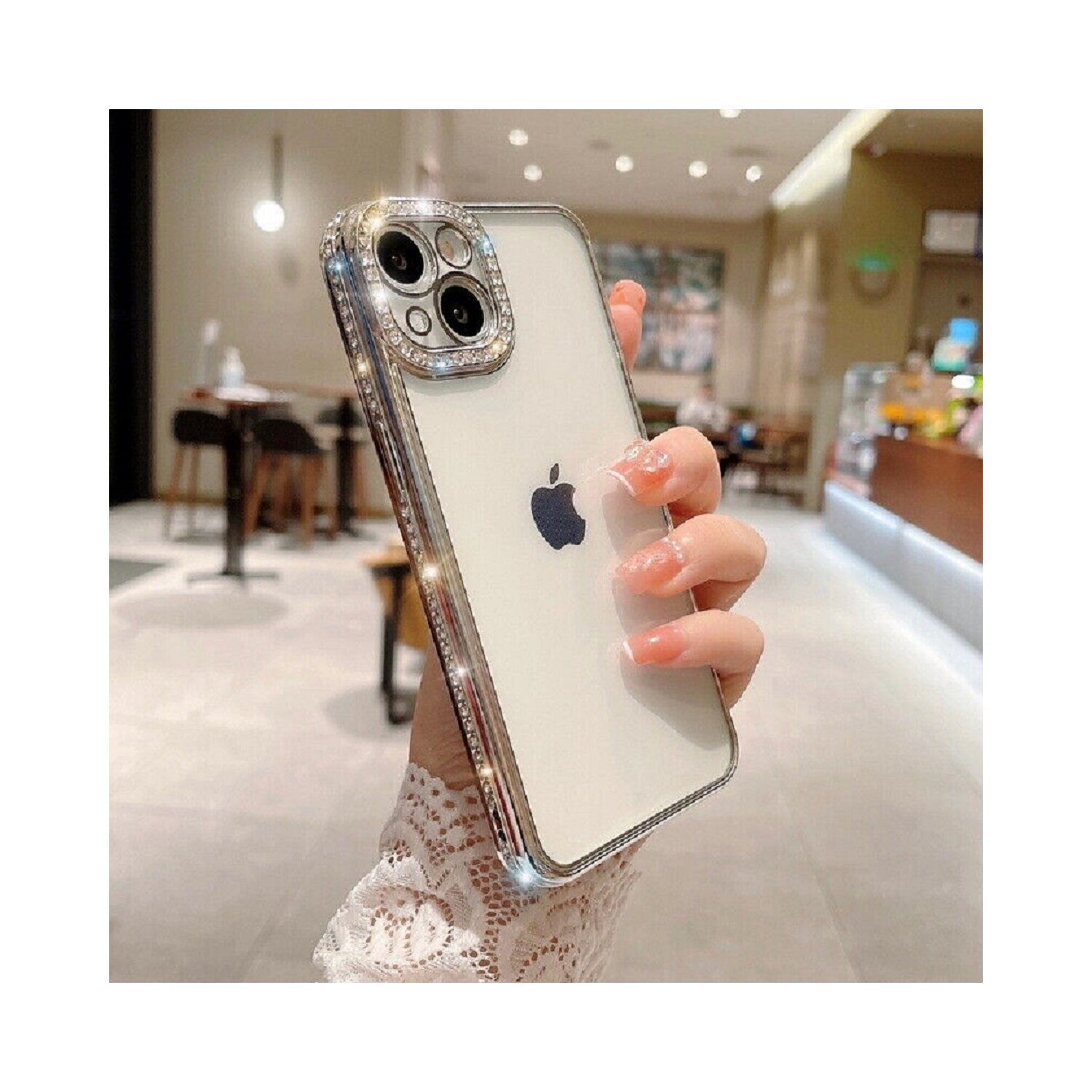 Una mano che tiene un telefono con una custodia gioiello. Il telefono ha il logo Apple.