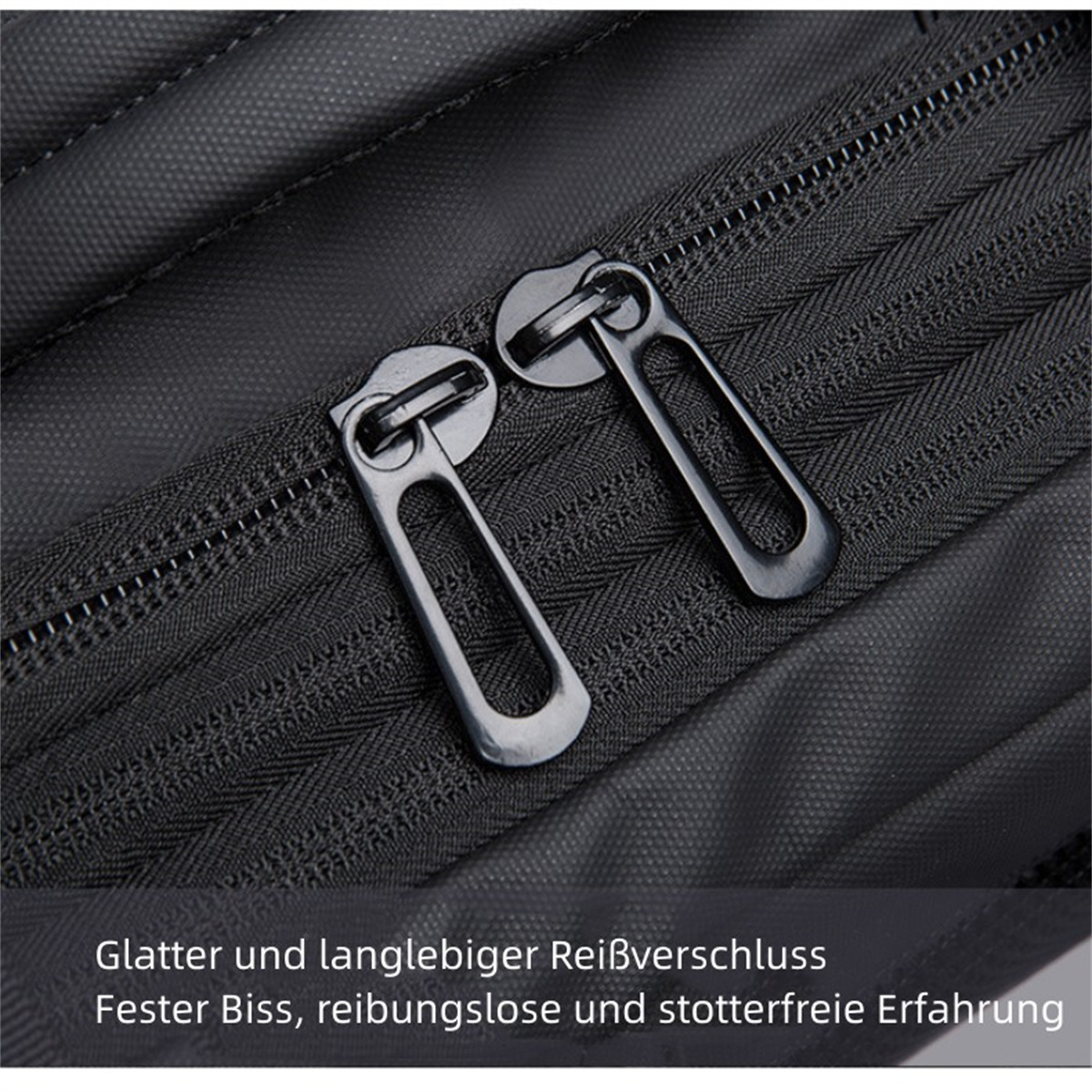 Nahaufnahme eines schwarzen Reißverschlusses mit zwei metallischen Ziehern. Text unten auf Deutsch.