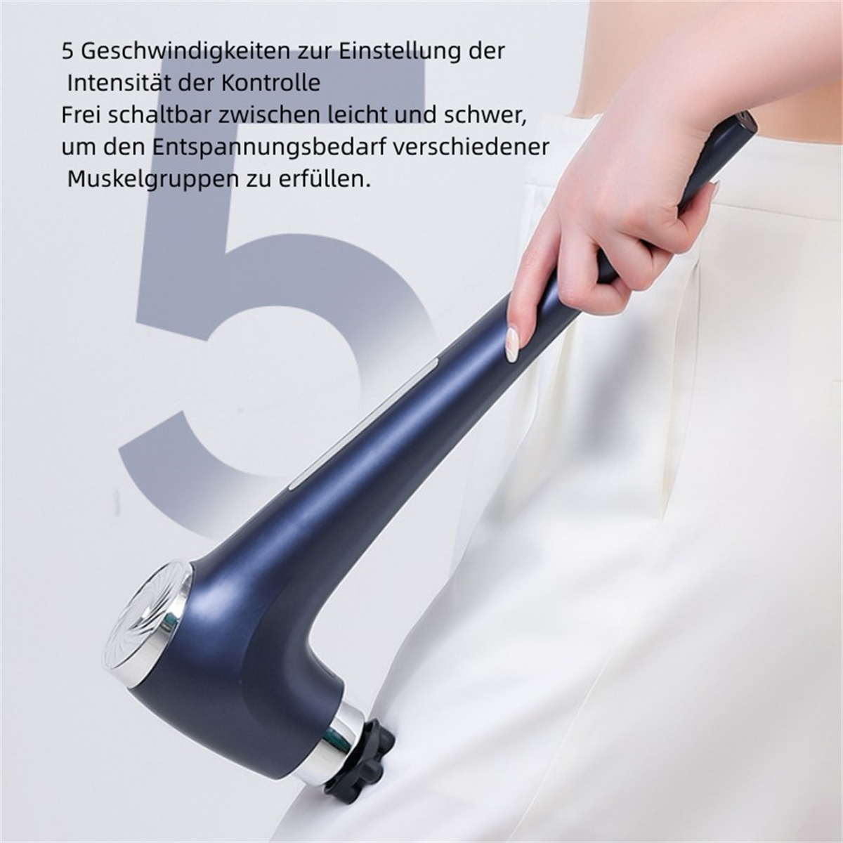 Ein Massagegerät mit dunkelblauem Griff, gehalten von einer Person, die eine weiße Hose trägt.