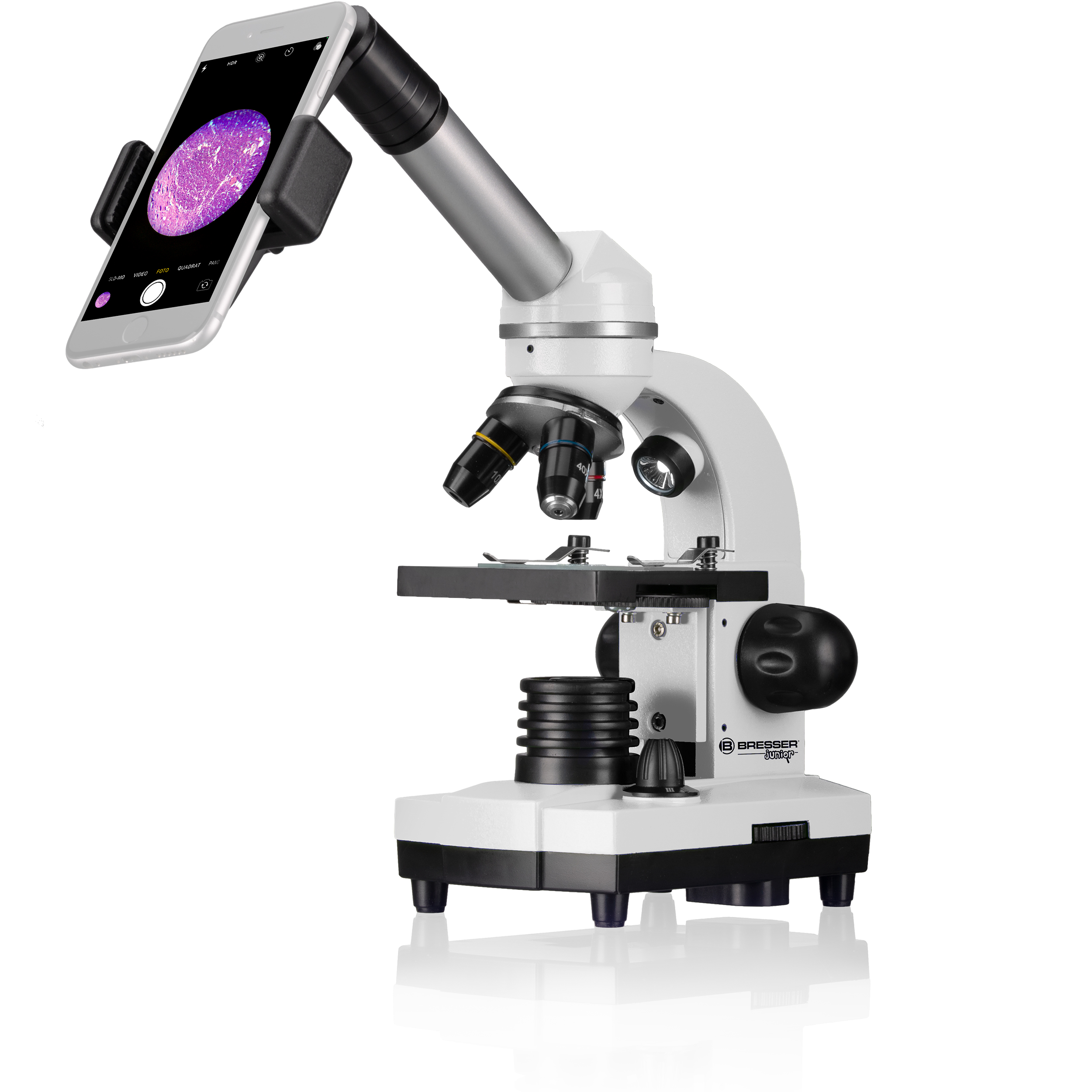 Un microscopio blanco con un teléfono adjunto. El teléfono muestra una imagen rosa.