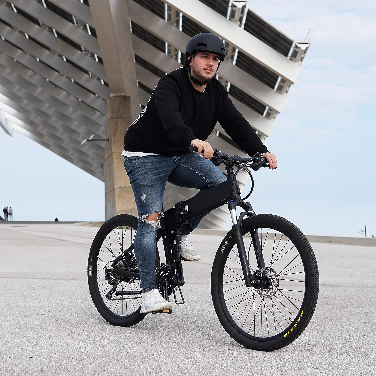 Ein Mann fährt an einem sonnigen Tag mit einem schwarzen Elektrofahrrad.