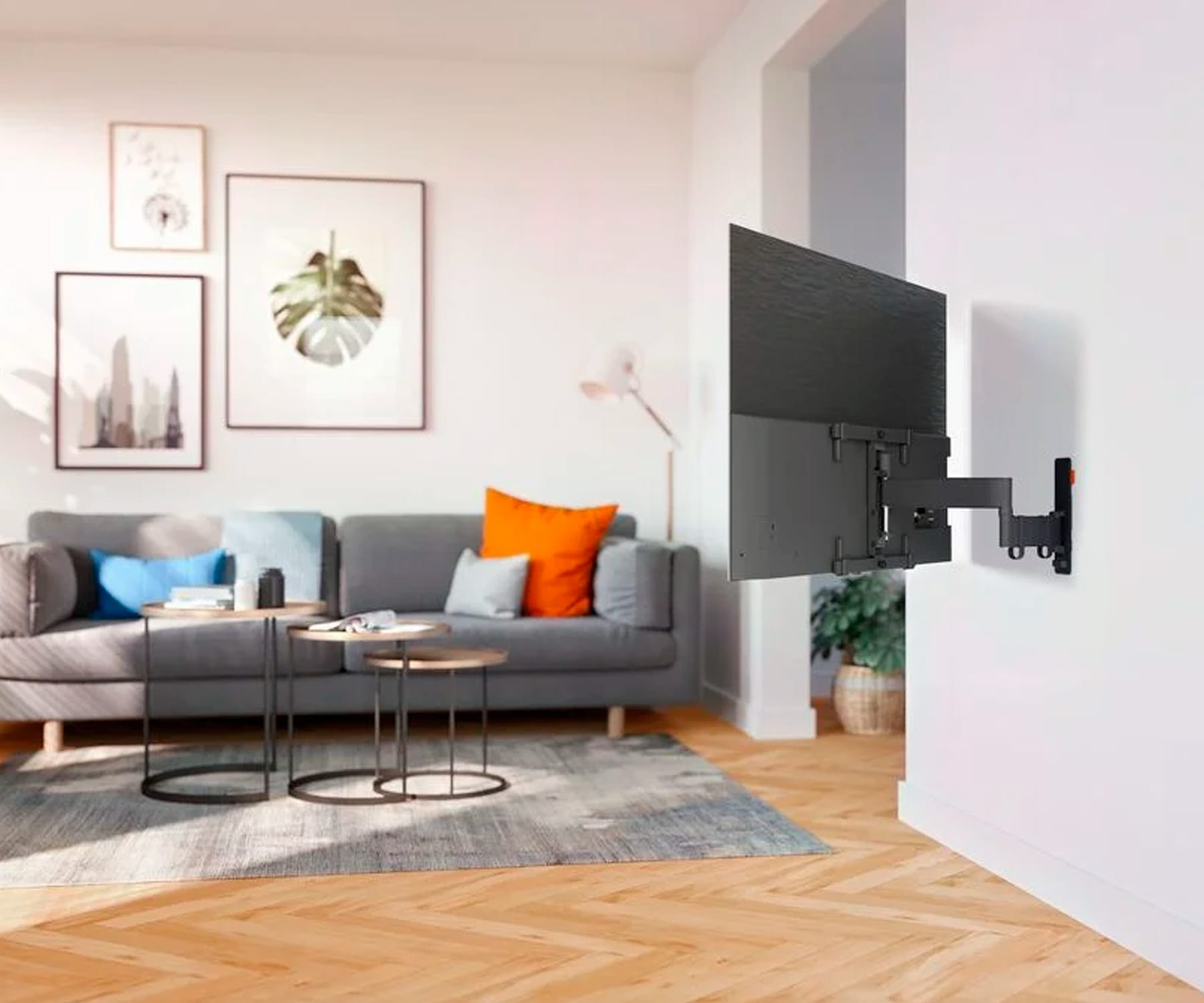 Salon z zamontowanym telewizorem, sofą, stolikami kawowymi i grafiką ścienną.