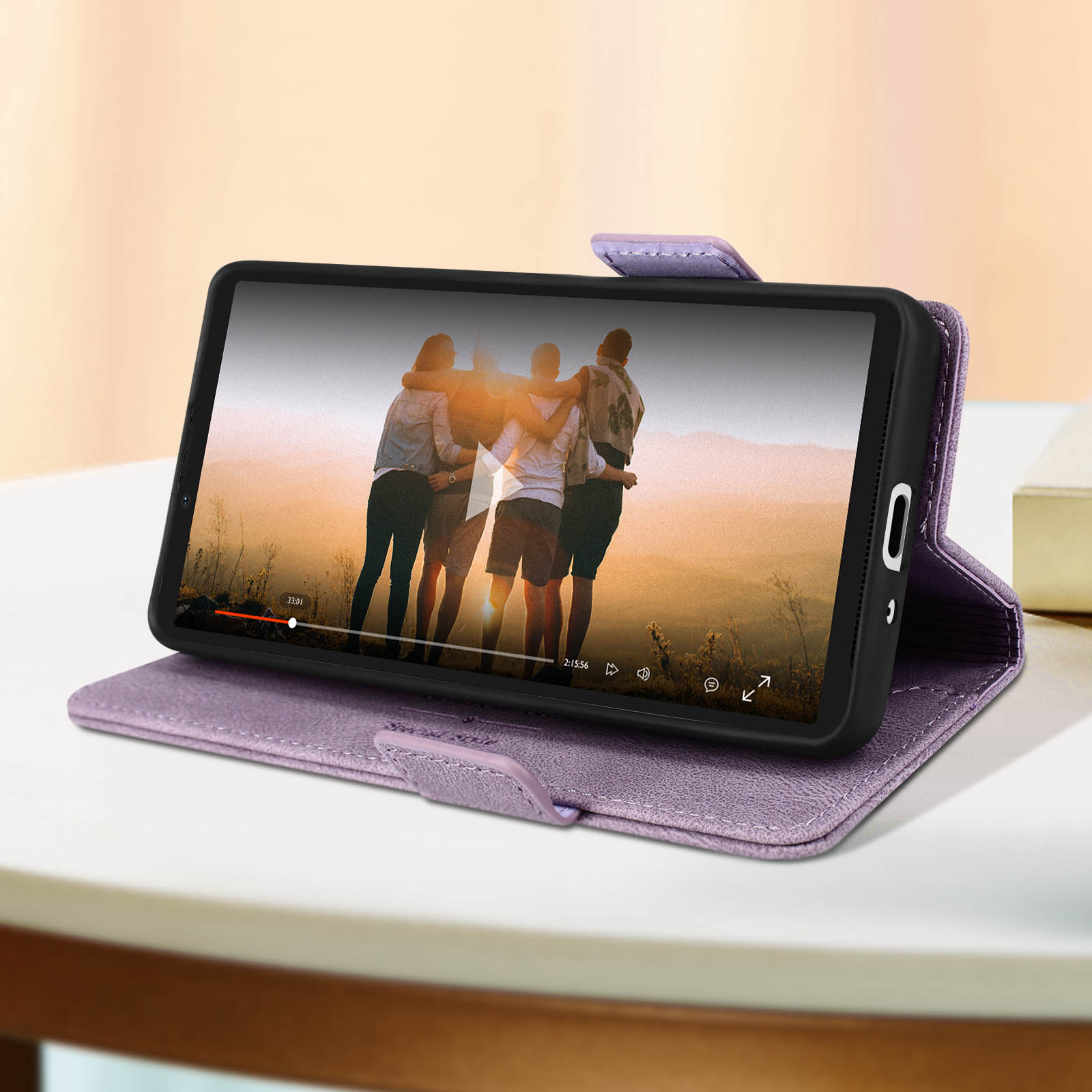 Telefono in custodia viola, che mostra un video. Sfondo tavolo.