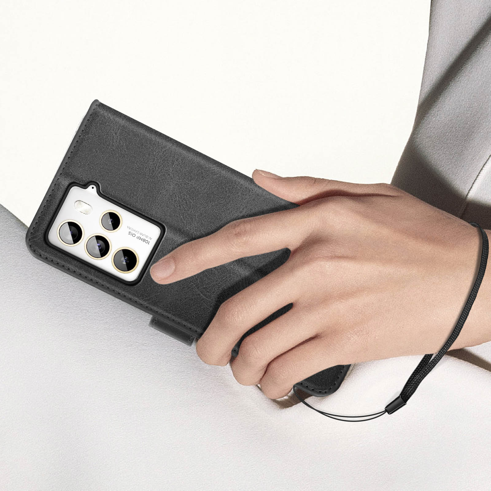 La mano di una persona tiene una custodia nera per telefono. La custodia ha un design a portafoglio.