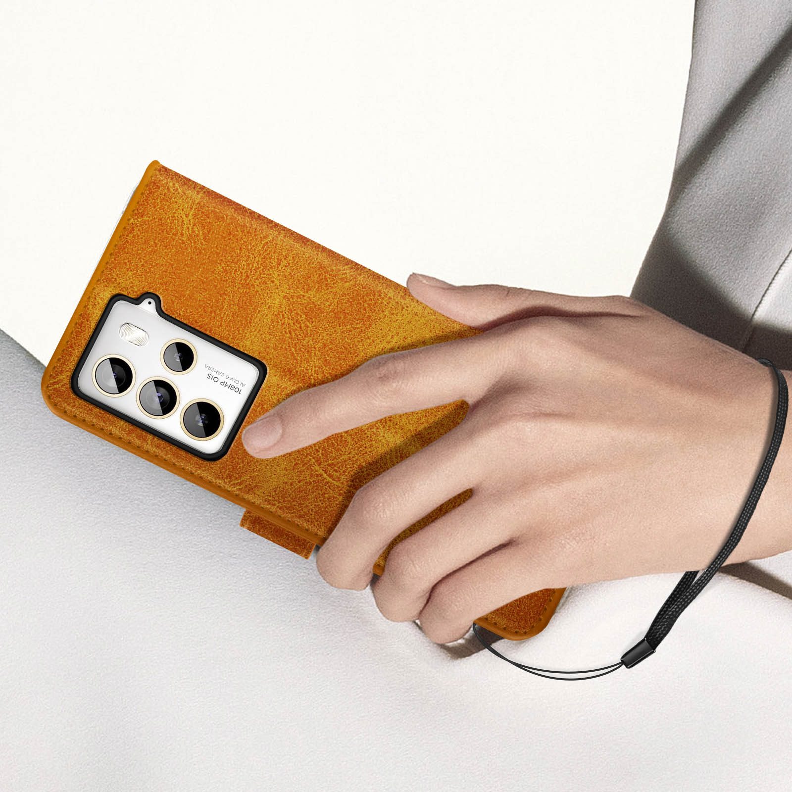 La mano di una persona tiene una custodia per telefono in pelle marrone con più lenti della fotocamera.
