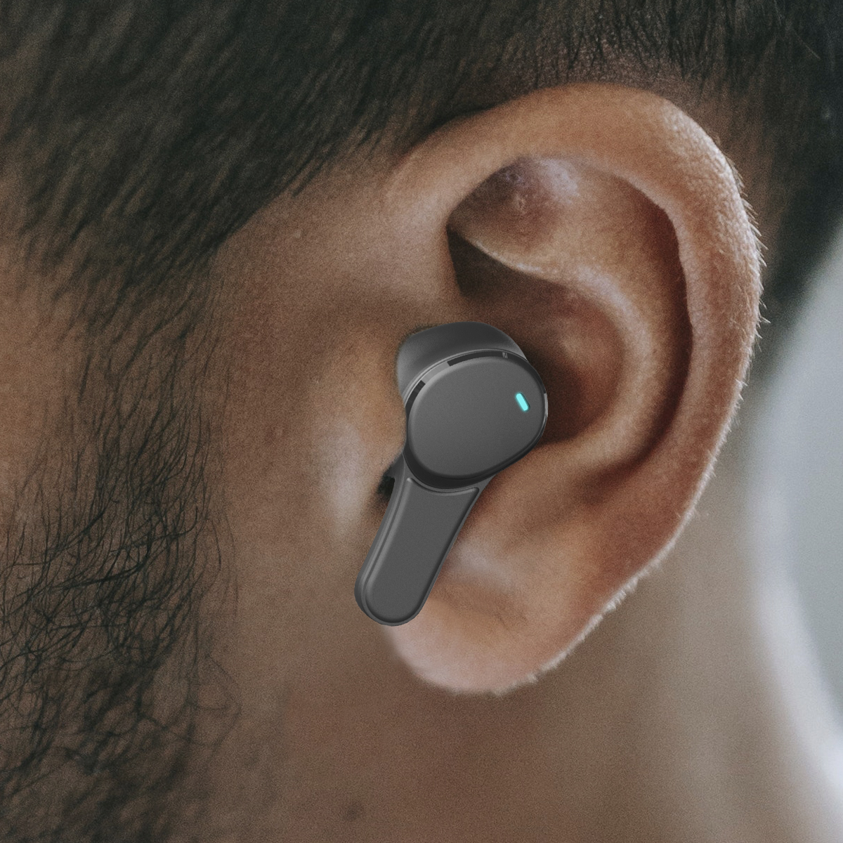 Słuchawka w uchu osoby. Czarny kolor z niebieskim światłem.