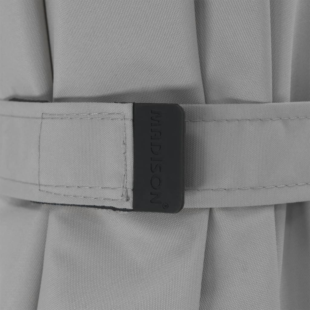 A close-up of a gray strap with the word "MADISON" on it. It is part of a sunshade.