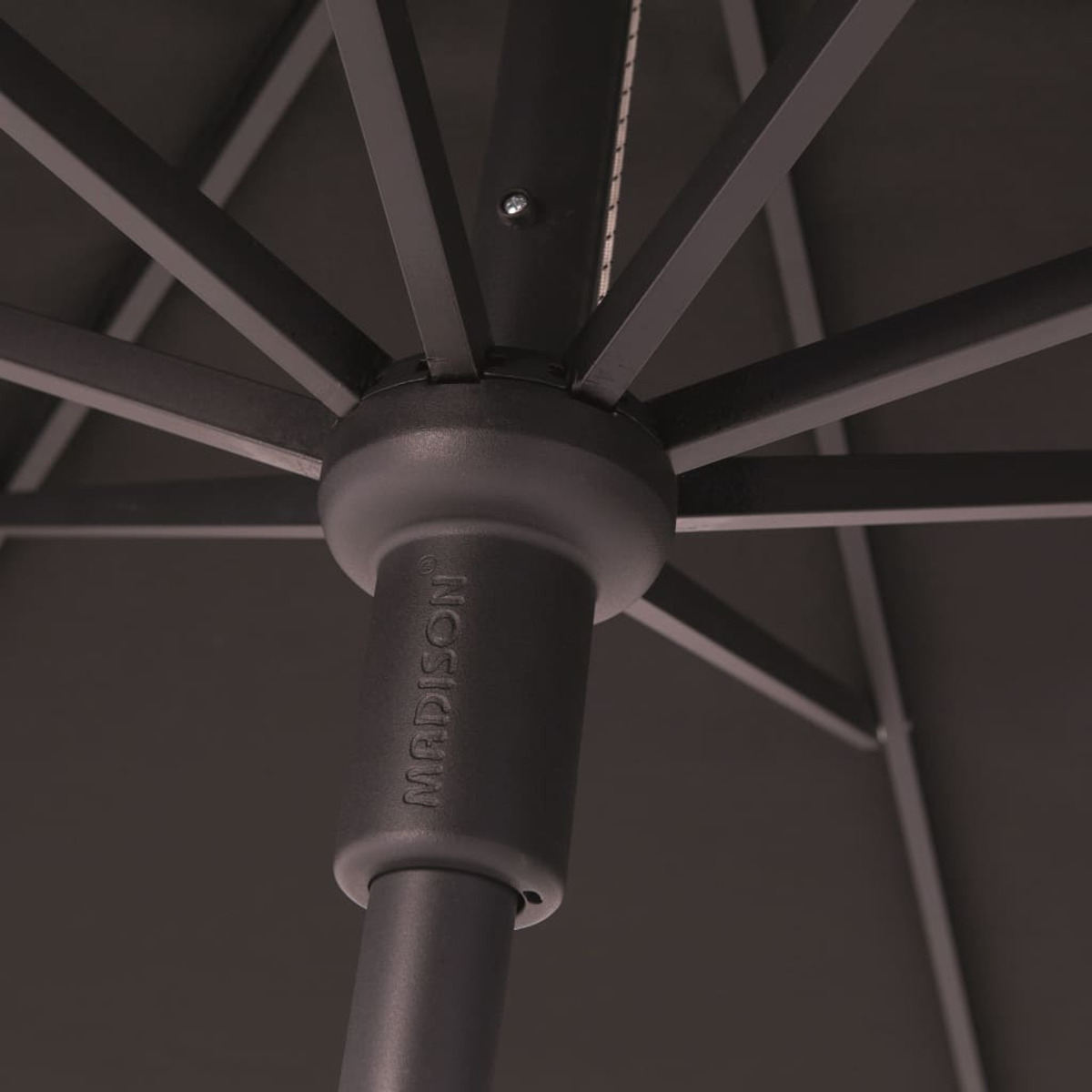 Close-up of a black umbrella's central pole and part of the fabric, with the brand name visible.