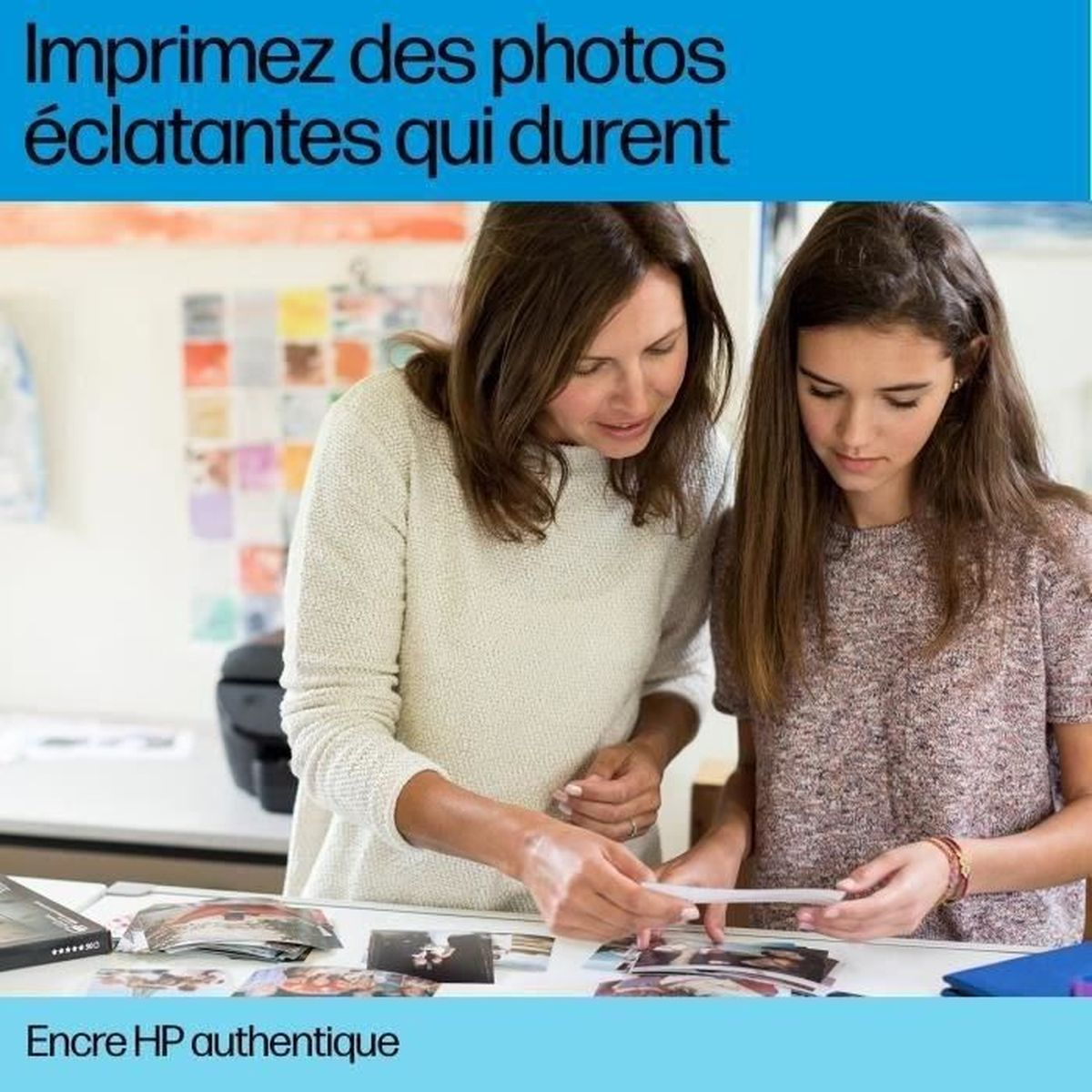 Frau und Mädchen betrachten Fotos auf einem Tisch, Drucker im Hintergrund.