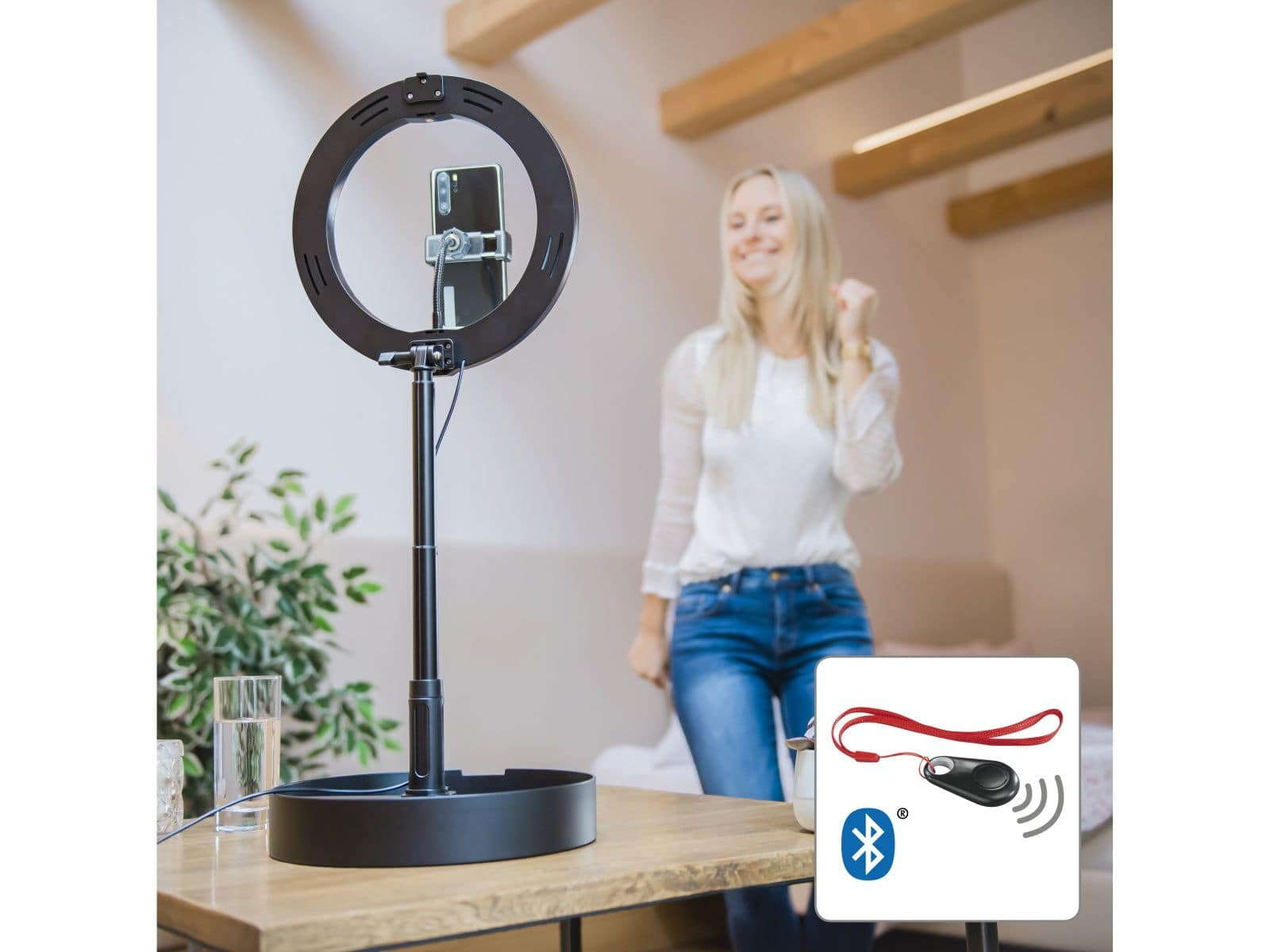 Kobieta używająca lampy pierścieniowej i telefonu. Pilot zdalnego sterowania w prawym dolnym rogu.